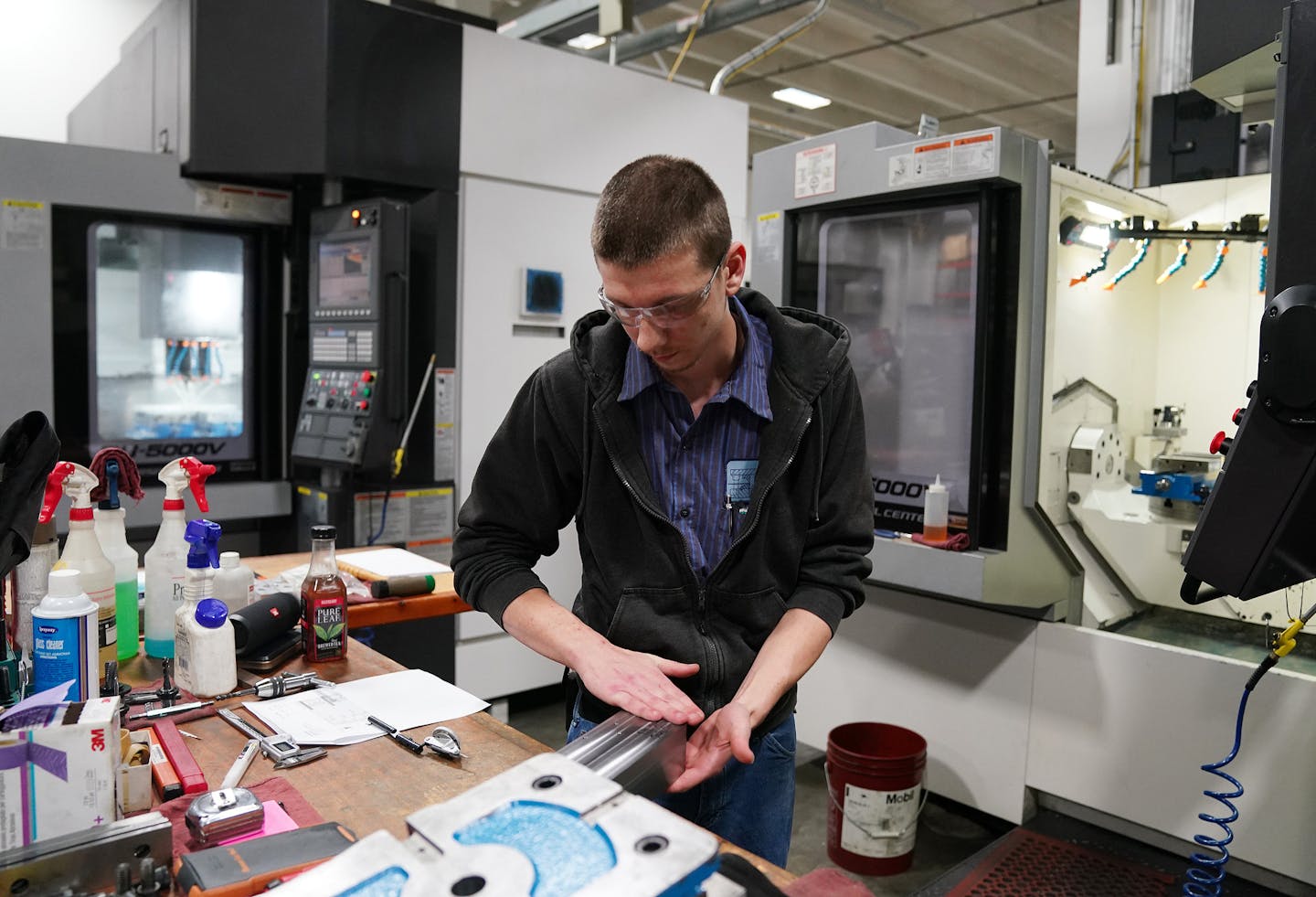 Machinist Derrik Richardson prepped a piece for the 5-axis computer numerical controlled milling machine behind him to fabricate various parts for the aerospace industry. ] ANTHONY SOUFFLE &#x2022; anthony.souffle@startribune.com Interview and tour with MRG Tool and Die president Rod Gramse of his facilities to discuss manufacturing on the job training Wednesday, Jan. 23, 2020 in Faribault, Minn.