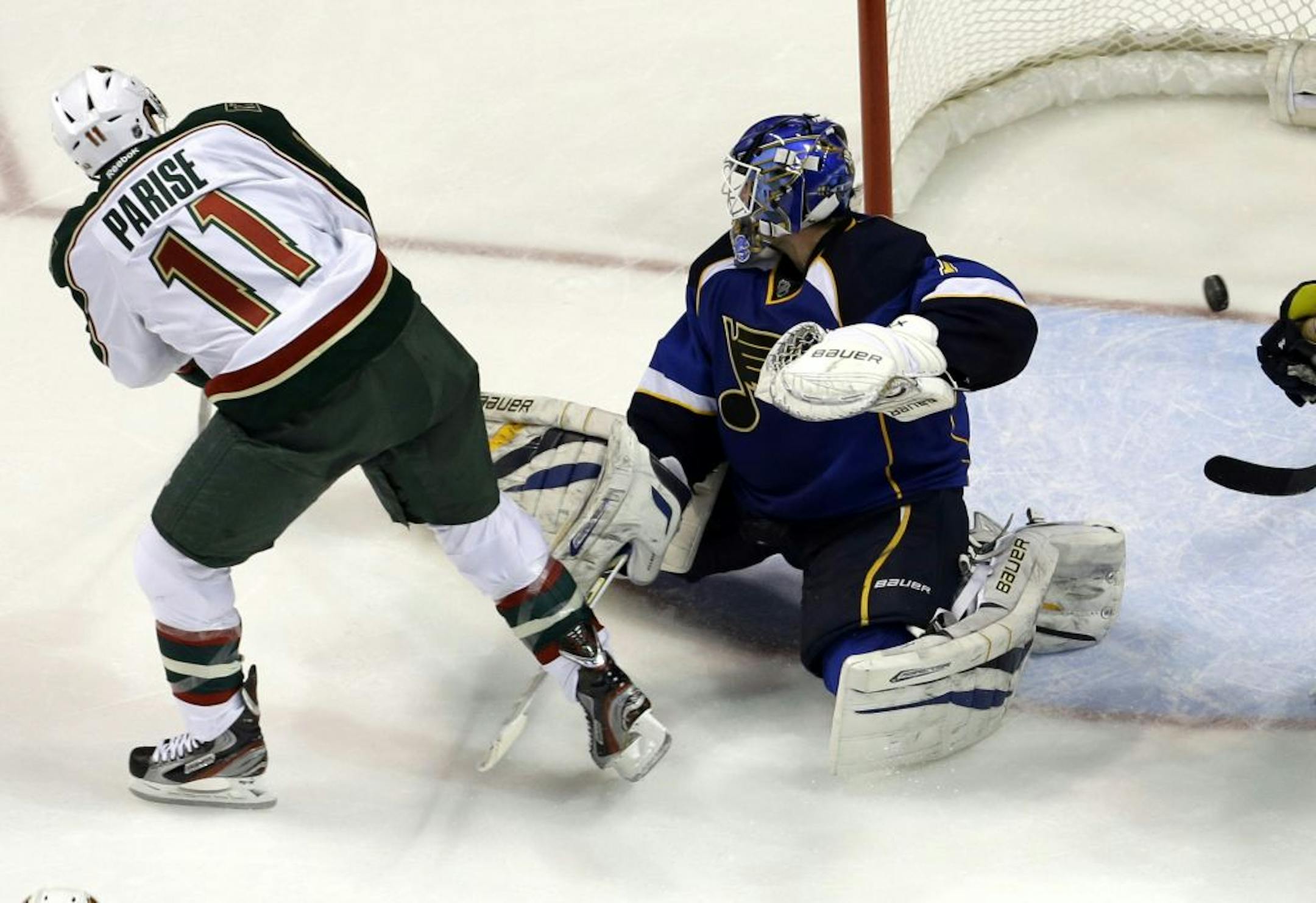 Minnesota Wild's Zach Parise, left, scores past St. Louis Blues goalie Brian Elliott during the second period of an NHL hockey game Sunday, Jan. 27, 2013, in St. Louis.