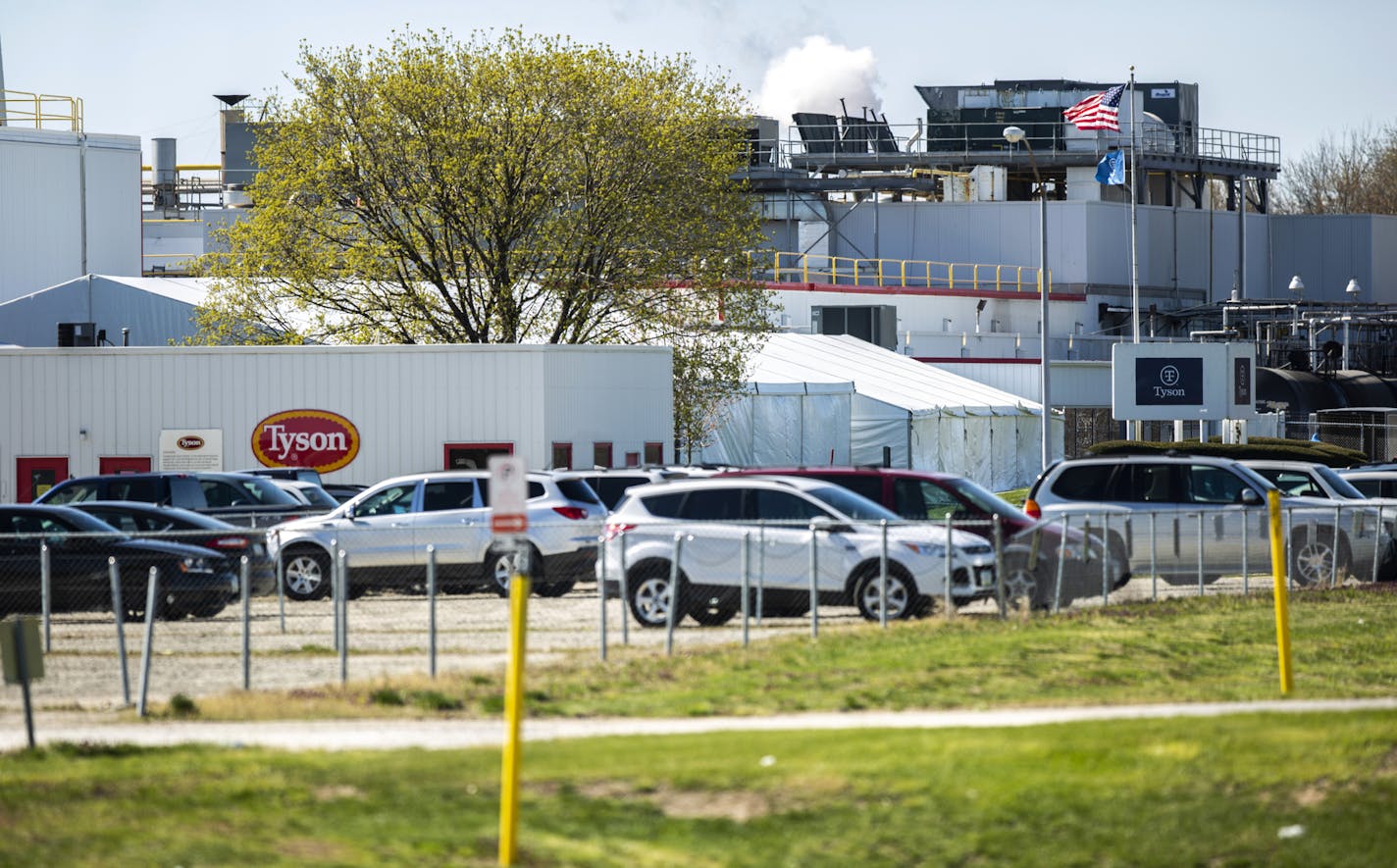 In this Tuesday, April 21, 2020 photo, vehicles are seen in the parking lot on the first day of a temporary shutdown at a Tyson Foods pork processing plant in Columbus Junction, Iowa., due to an outbreak of COVID-19.