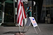A man walks by a voting sign at the Minneapolis Central Library during the August 2022 primary election in Minneapolis. Early voting begins Sept. 22 f