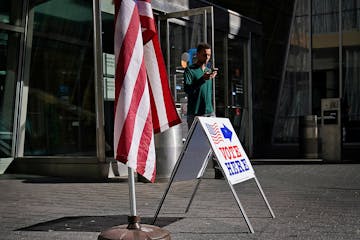 A man walks by a voting sign at the Minneapolis Central Library during the August 2022 primary election in Minneapolis. Early voting begins Sept. 22 f