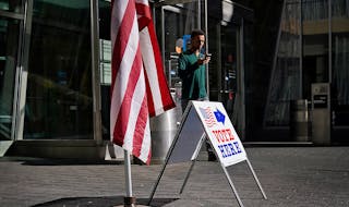 A man walks by a voting sign at the Minneapolis Central Library during the August 2022 primary election in Minneapolis. Early voting begins Sept. 22 f