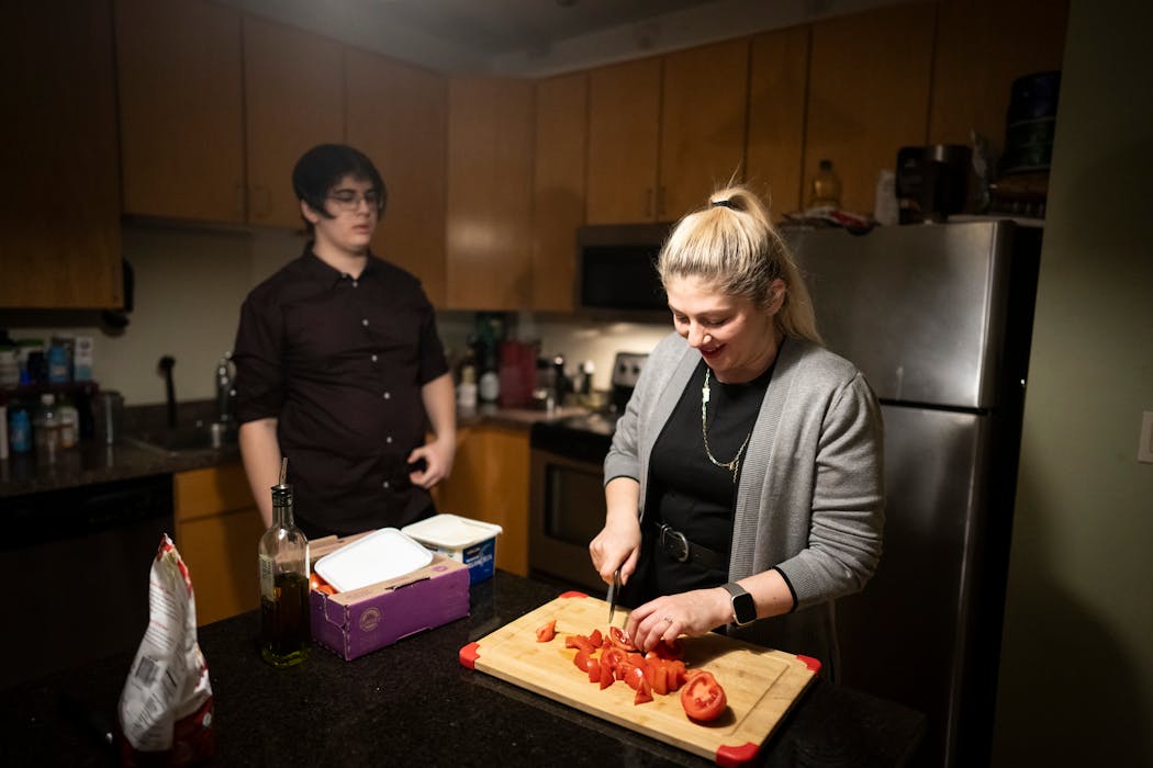 Olena Khuder made a salad with 15-year-old son Ahmed, one of the family's three children, at their home in Minneapolis.