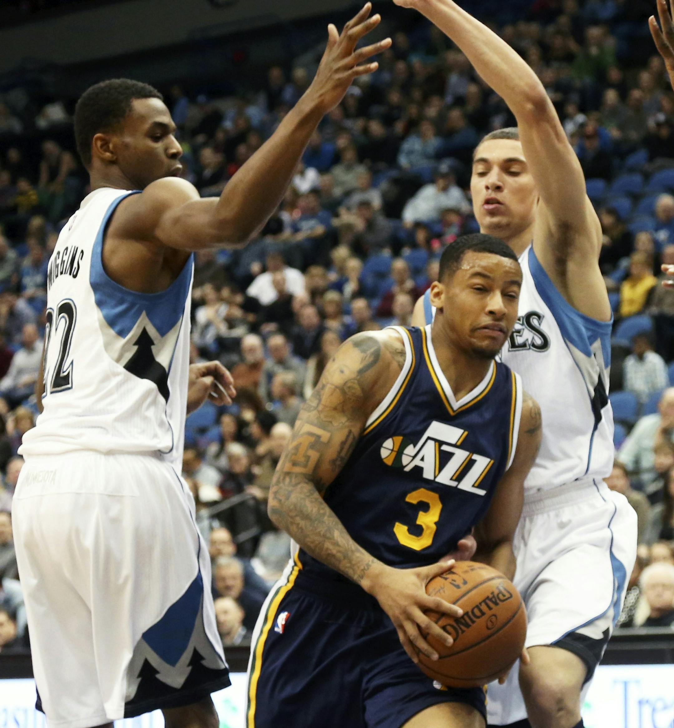 Utah Jazz&#x2019;s Trey Burke, center, drives between Minnesota Timberwolves&#x2019; Andrew Wiggins, left, and Zach LaVine, right, in the first quarter of an NBA basketball game, Saturday, Jan. 3, 2015, in Minneapolis. (AP Photo/Jim Mone)