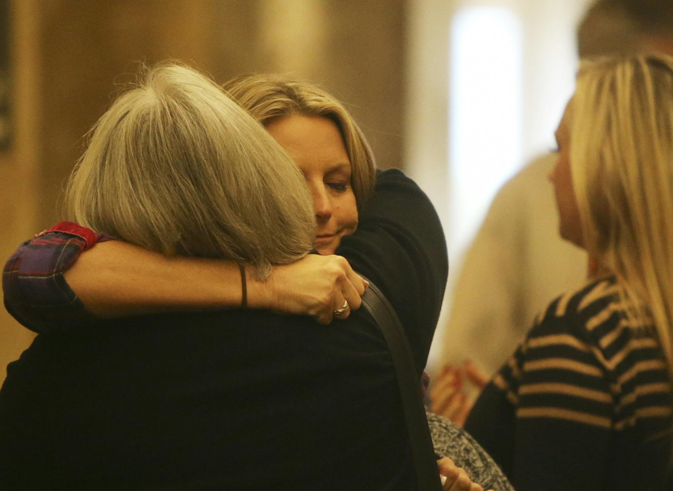 Unidentified family members of Kira Steger hug while waiting for an elevator to take them to the courtroom for the start of the murder trial of Jeffrey Trevino, Kira's husband Thursday, Sept. 19, 2013, at the Ramsey County Courthouse in St. Paul, MN.