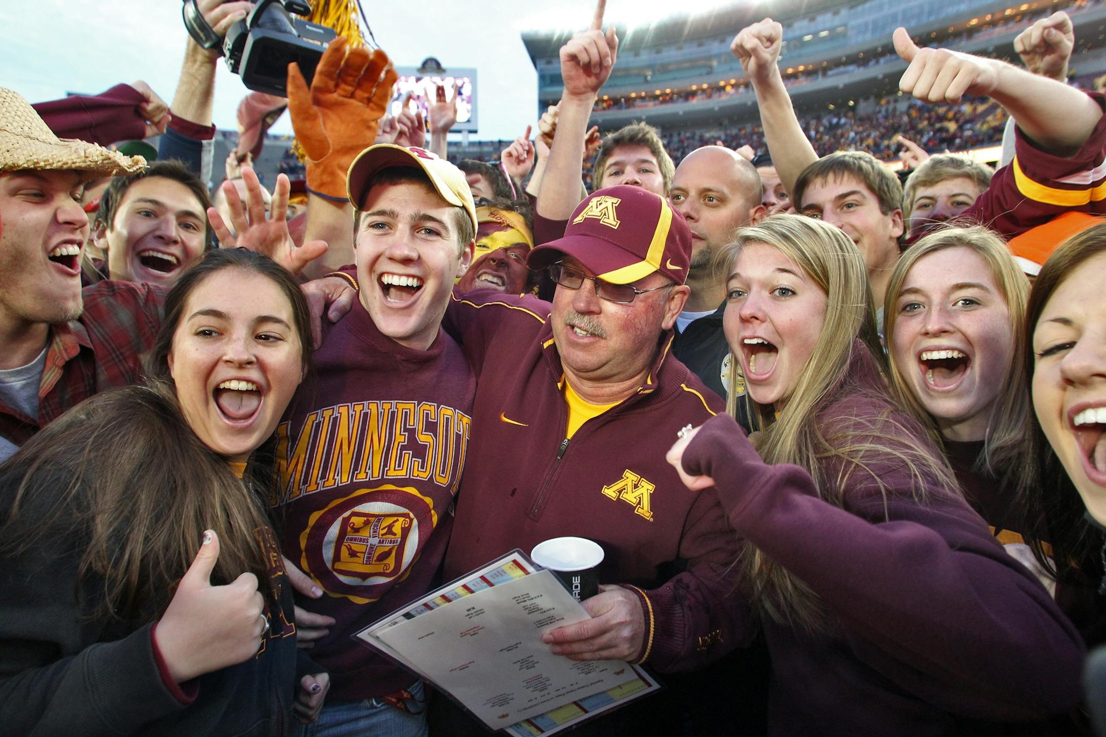 Minnesota Gophers vs. Iowa Hawkeyes football. Minnesota won 22-21. Head football coach Jerry Kill, center celebrated with fans on the field at the end of the game.