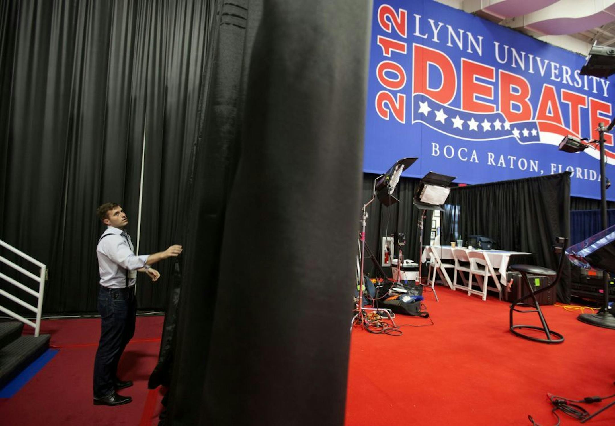 A campaign worker works on the set for the spin corner for the President Barack Obama campaign in the media center ahead of Monday's presidential debate between Republican presidential candidate, former Massachusetts Gov. Mitt Romney and Obama, Sunday, Oct. 21, 2012, at Lynn University in Boca Raton, Fla.