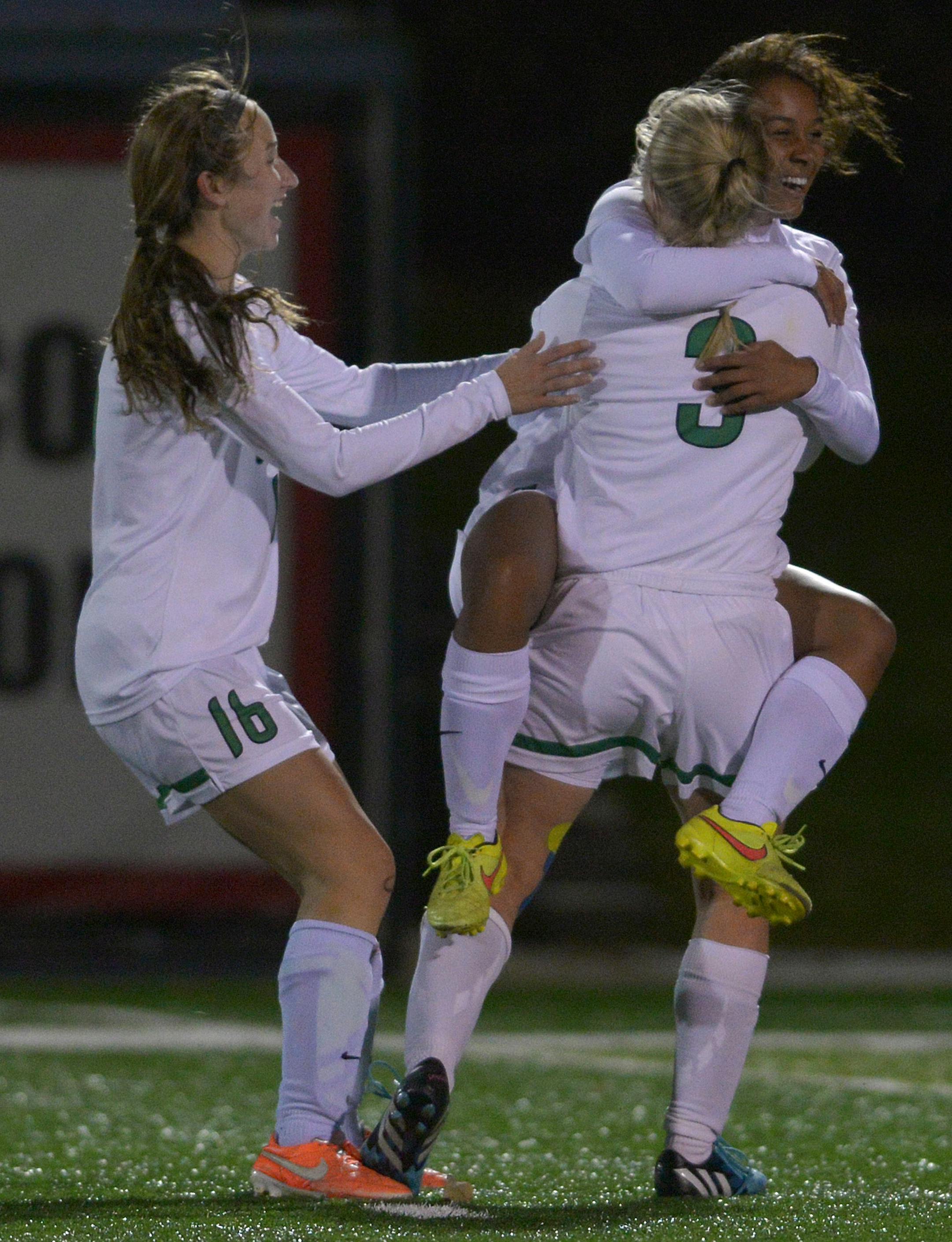 Eagan's Jade King celebrates her 27 yard goal on Eden Prairie goalkeeper Lindsay Eliasen with teammates Hannah Pavek (16) and Hannah Jacobson (3) during the first half of the Class 2A Girls' championship game Thursday, October 30 at Husky Stadium in St. Cloud. Eagan led Eden Prairie 1-0 at halftime. ] (SPECIAL TO THE STAR TRIBUNE/BRE McGEE) **Jade King (white, in arms), Lindsay Eliasen (goalkeeper, not pictured), Hannah Pavek (white, 16), Hannah Jacobson (white, 3)