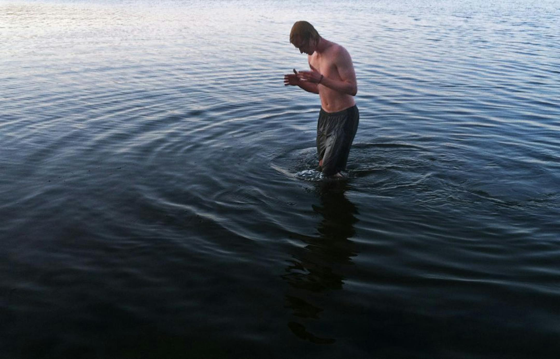 On Lake Harriet, Mike Meline,18 of Minneapolis took an "ice bath" to cool down and prevent soreness after running. He is looking forward to playing ultimate frisbee this spring .
