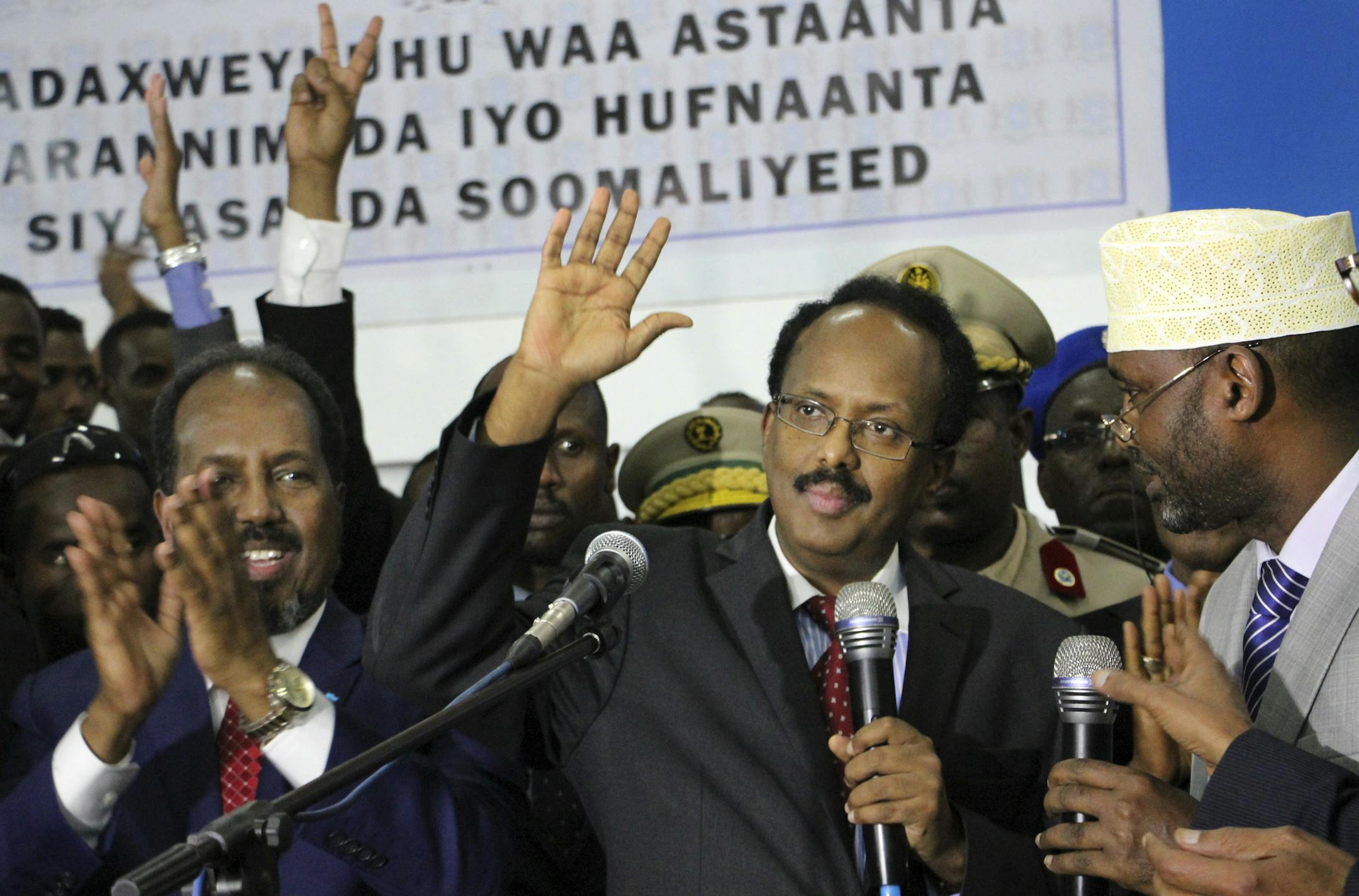 New Somali President Mohamed Abdullahi Mohamed, known by his nickname “Farmajo,” second right, waves to supporters as he is joined by incumbent President Hassan Sheikh Mohamud, left, after winning the election in Mogadishu, Somalia, on Wednesday. Farmajo, who holds dual Somali-U.S. citizenship, immediately took the oath of office as the long-chaotic country moved toward its first fully functioning central government in a quarter-century.