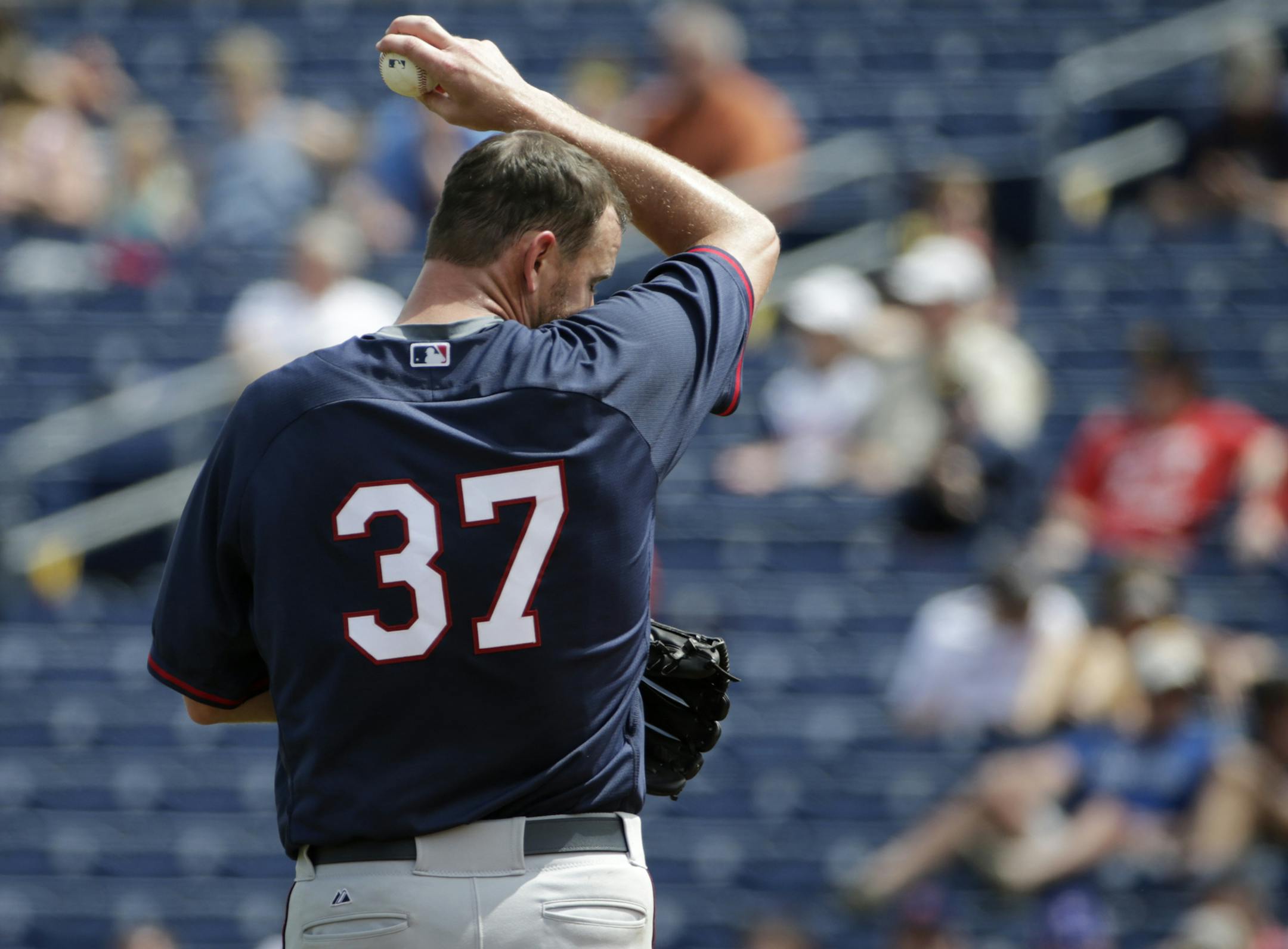 Minnesota Twins starting pitcher Mike Pelfrey (37) wipes his face on his jersey in the second inning of a spring training baseball game against the Philadelphia Phillies in Clearwater, Fla., Monday, March 23, 2015. The Phillies defeated the Twins 3-0. (AP Photo/Kathy Willens)