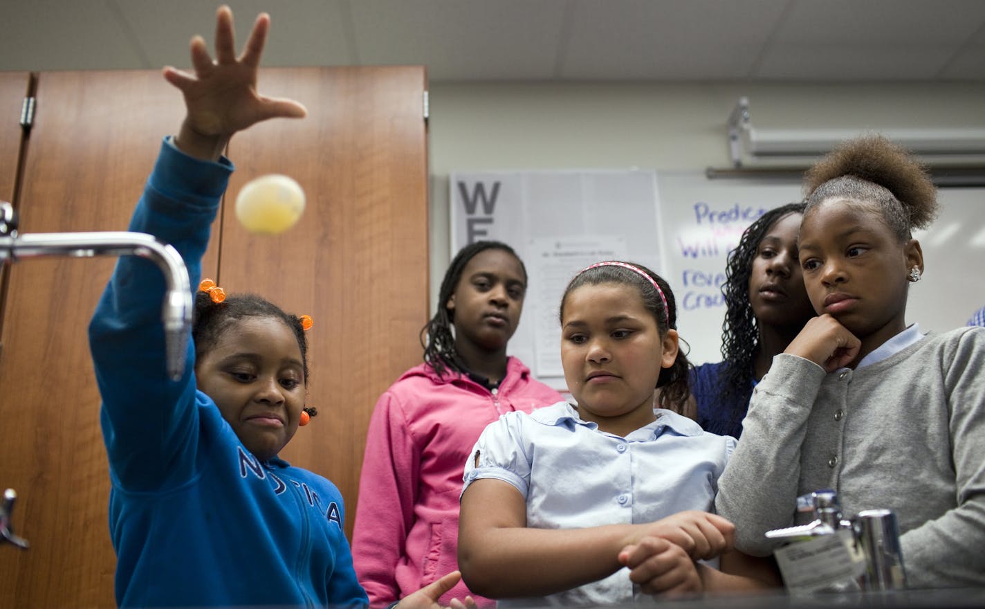 Davosha Holmes drops an egg that has been soaking in vinegar for two days and has gone through oxidization process on Wednesday, April 30, 2014 at Rothenberg Preparatory Academy in Cincinnati, Ohio.