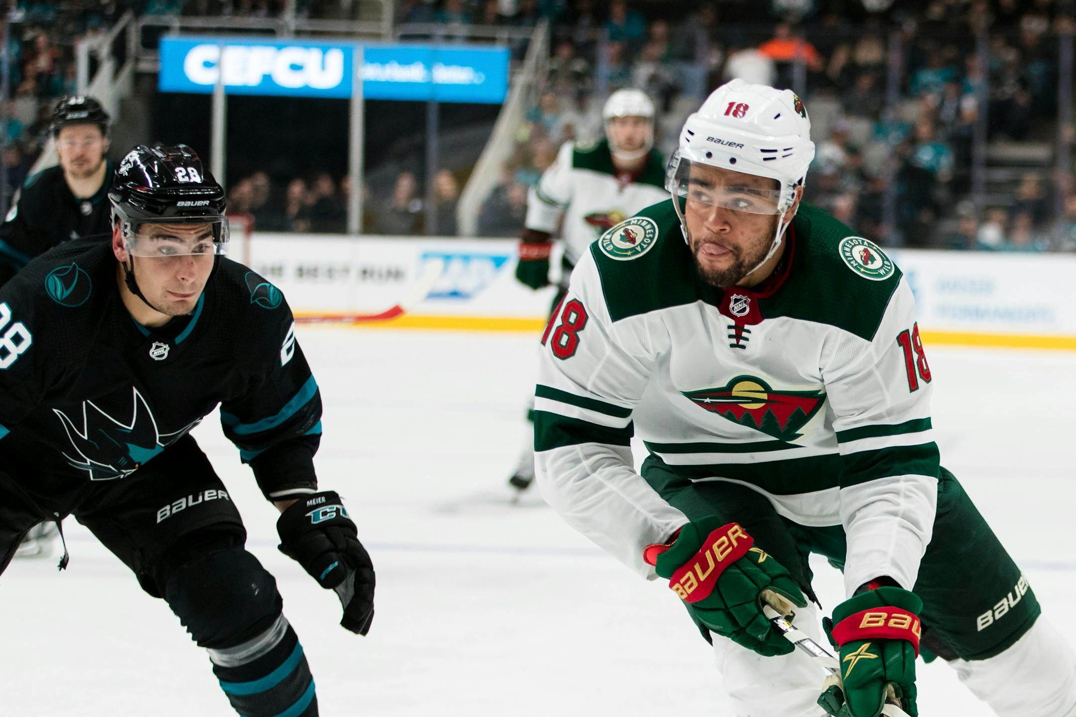 Minnesota Wild's Jordan Greenway (18) looks to pass as San Jose Sharks' Timo Meier (28) defends in the second period of an NHL hockey game, Thursday, Nov. 7, 2019, in San Jose, Calif. (AP Photo/John Hefti)