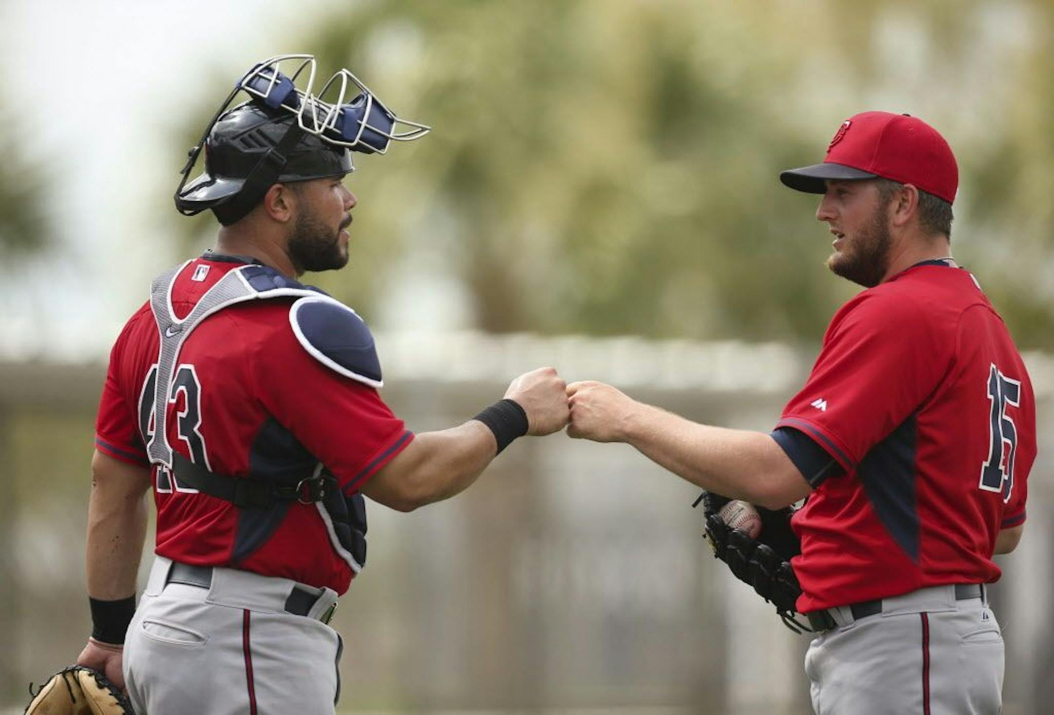Twins catcher Josmil Pinto and pitcher Glen Perkins bumped fists after Pinto caught for Perkins during batting practice Saturday morning at Hammond Stadium.