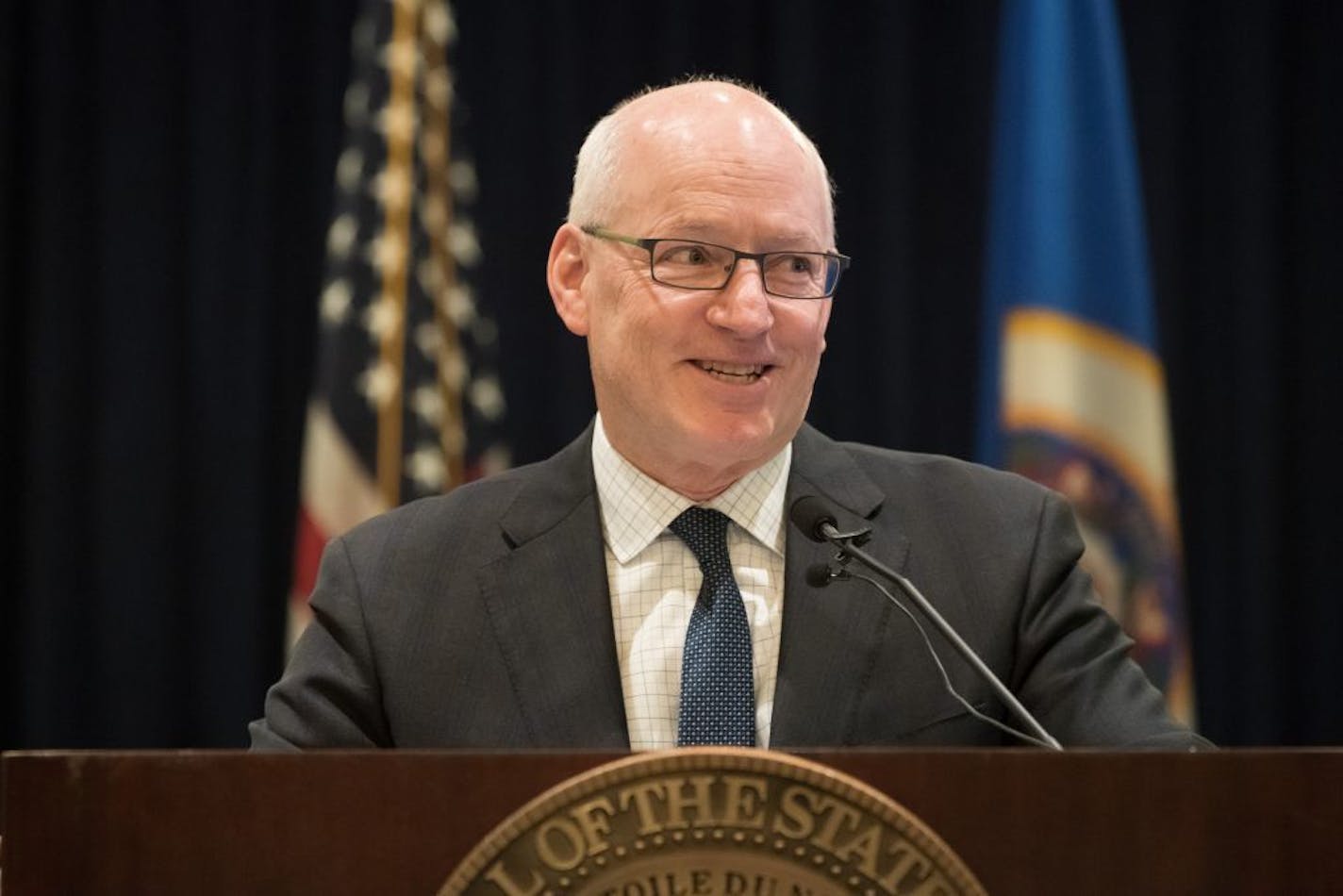 MMB Commissioner Myron Frans smiled as he touted Governor Dayton's policies the budget forecast press conference.