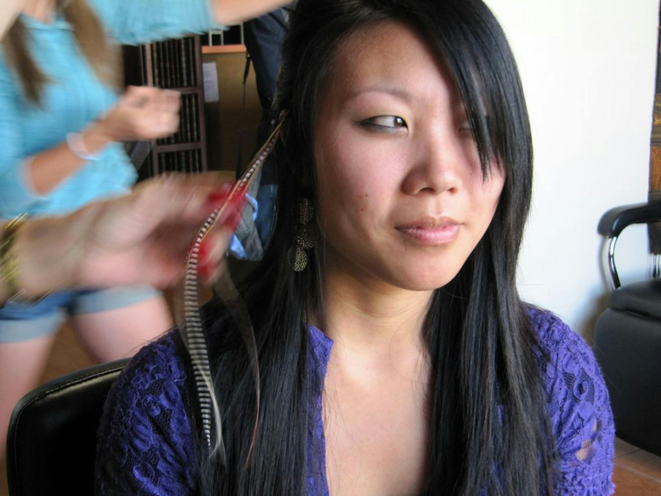 Kim Shanks gets feather extensions clipped into her hair at MiraBella Salon and Spa in Boise, Idaho.