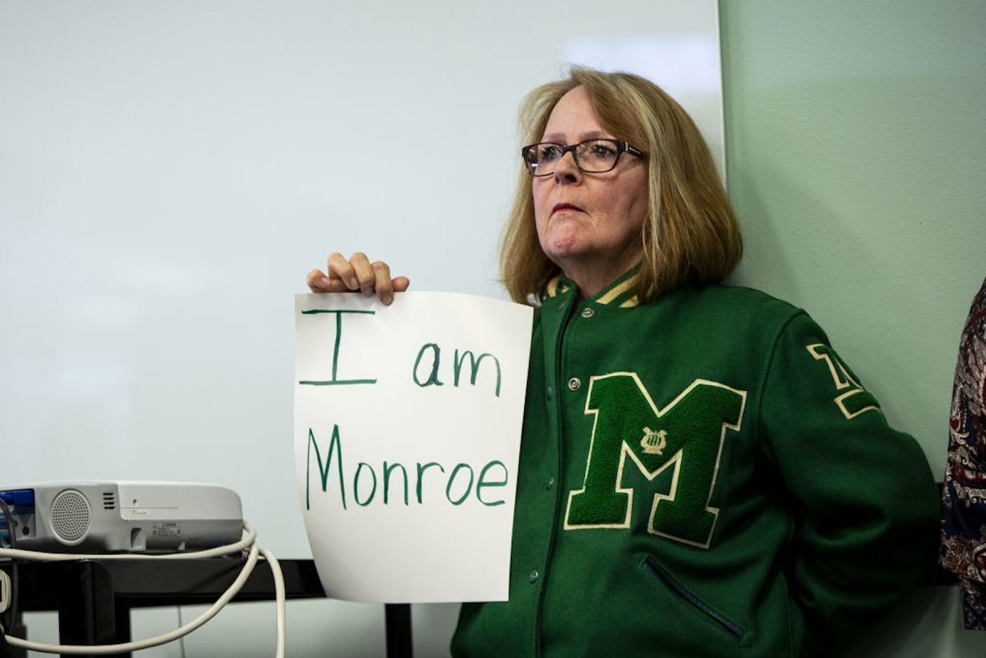 Joan Del Rio, Monroe High School class of 1976, holds a sign in protest against the proposed name change of the Linwood Monroe Arts Plus school to Global Arts Plus.