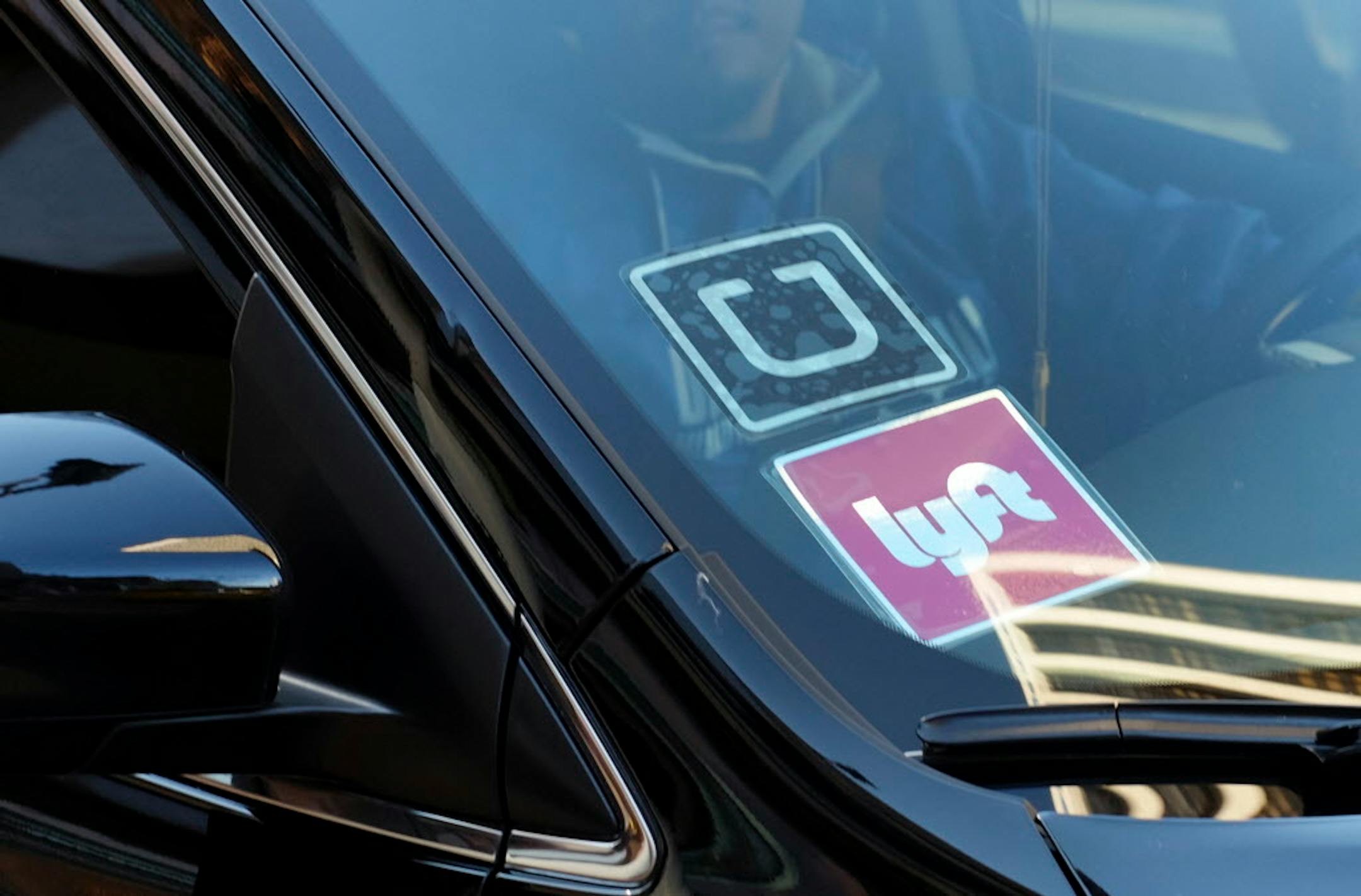Lyft and Uber stickers on a car in Los Angeles.
