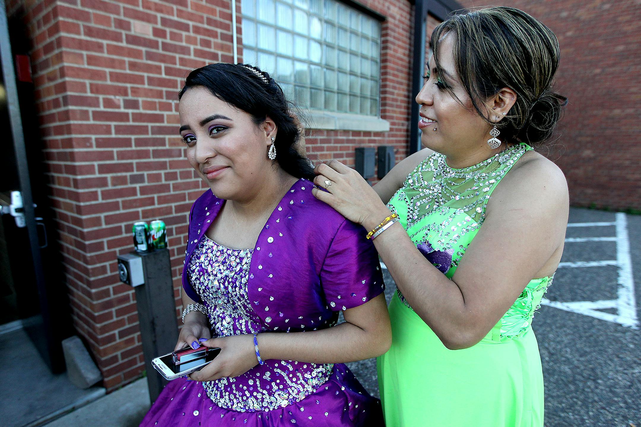 Patricia Omana, right, fixed her daughter's Lizeth Ortega's hair before making an entrance into the dance hall during her Quinceañera celebration at the West St. Paul Armory, Saturday, June 20, 2015. ] (ELIZABETH FLORES/STAR TRIBUNE) ELIZABETH FLORES • eflores@startribune.com
