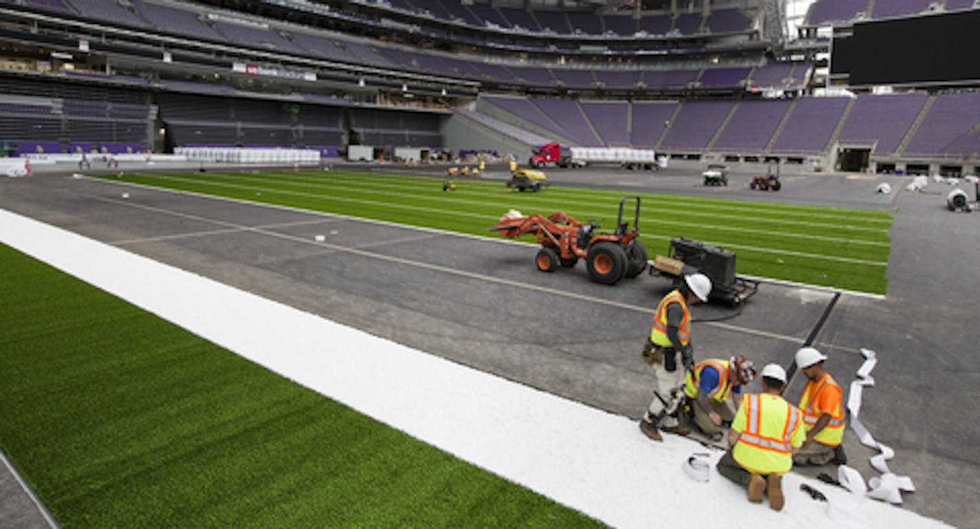 Workers lay down artificial turf at US Bank Stadium. ] (Leila Navidi/Star Tribune) leila.navidi@startribune.com BACKGROUND INFORMATION: Workers lay down turf at US Bank Stadium in Minneapolis on Tuesday, May 10, 2016.