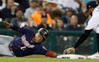 The Twins' Jorge Polanco reaches back to safely to touch third as Tigers third baseman Dawel Lugo attempts the tag during a recent game.