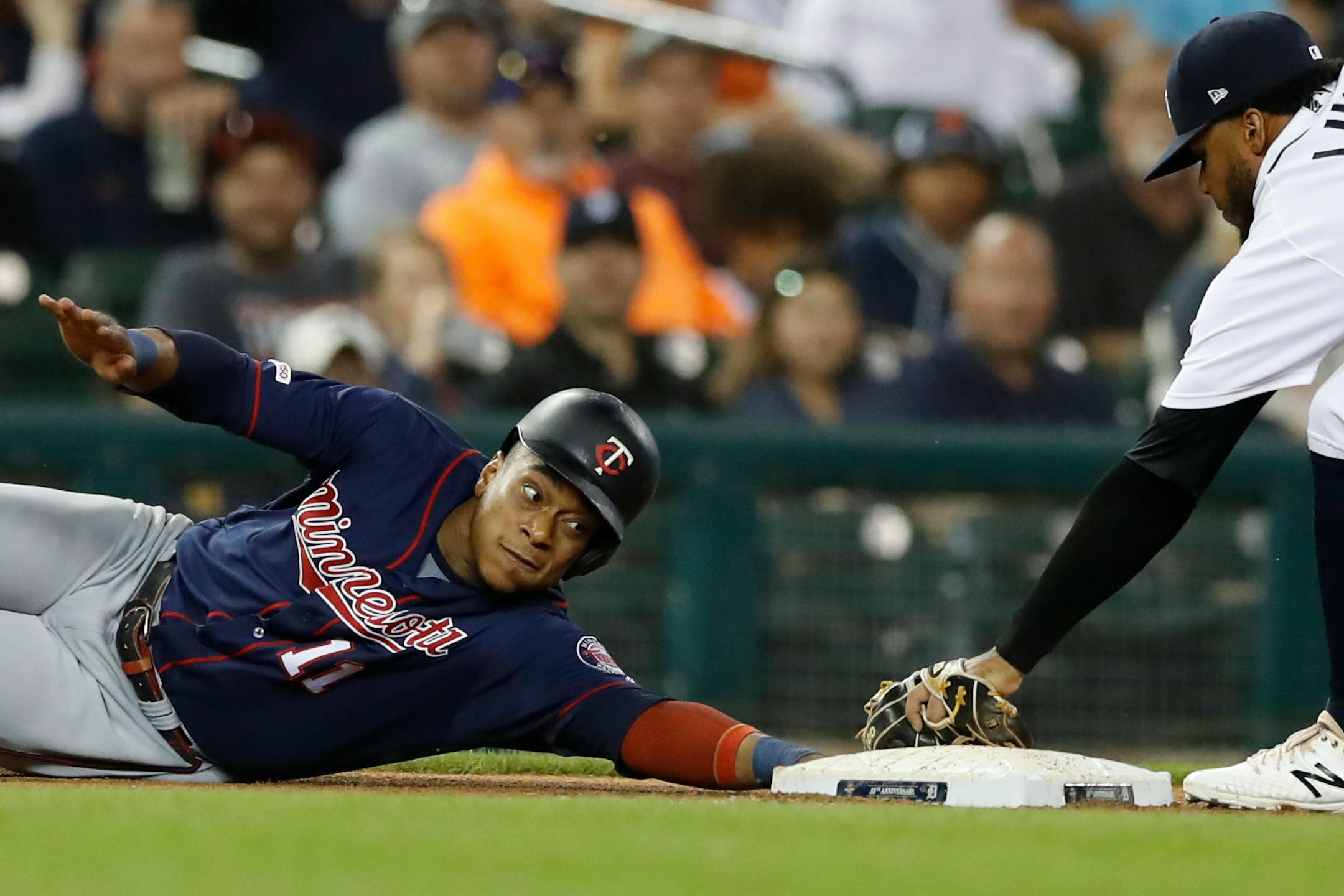 The Twins' Jorge Polanco reaches back to safely to touch third as Tigers third baseman Dawel Lugo attempts the tag during a recent game.