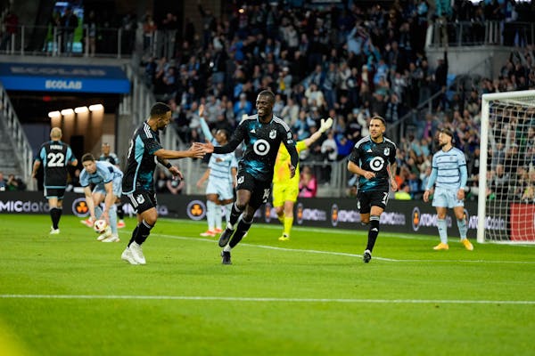Minnesota United striker Tani Oluwaseyi, center, gets a high-five from  right wingback DJ Taylor after Oluwaseyi scored against Sporting Kansas City o