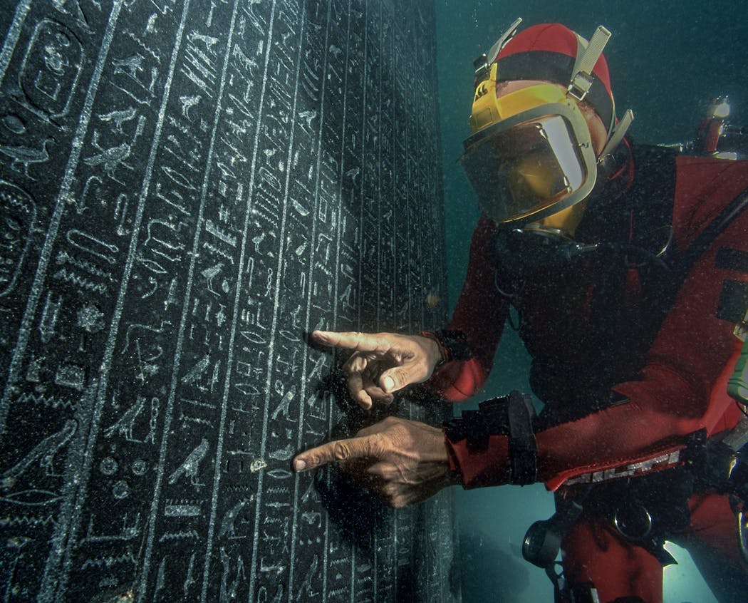 An underwater archaeologist examined a stele, or welcome sign, for Thonis-Heracleion in Aboukir Bay, Egypt.