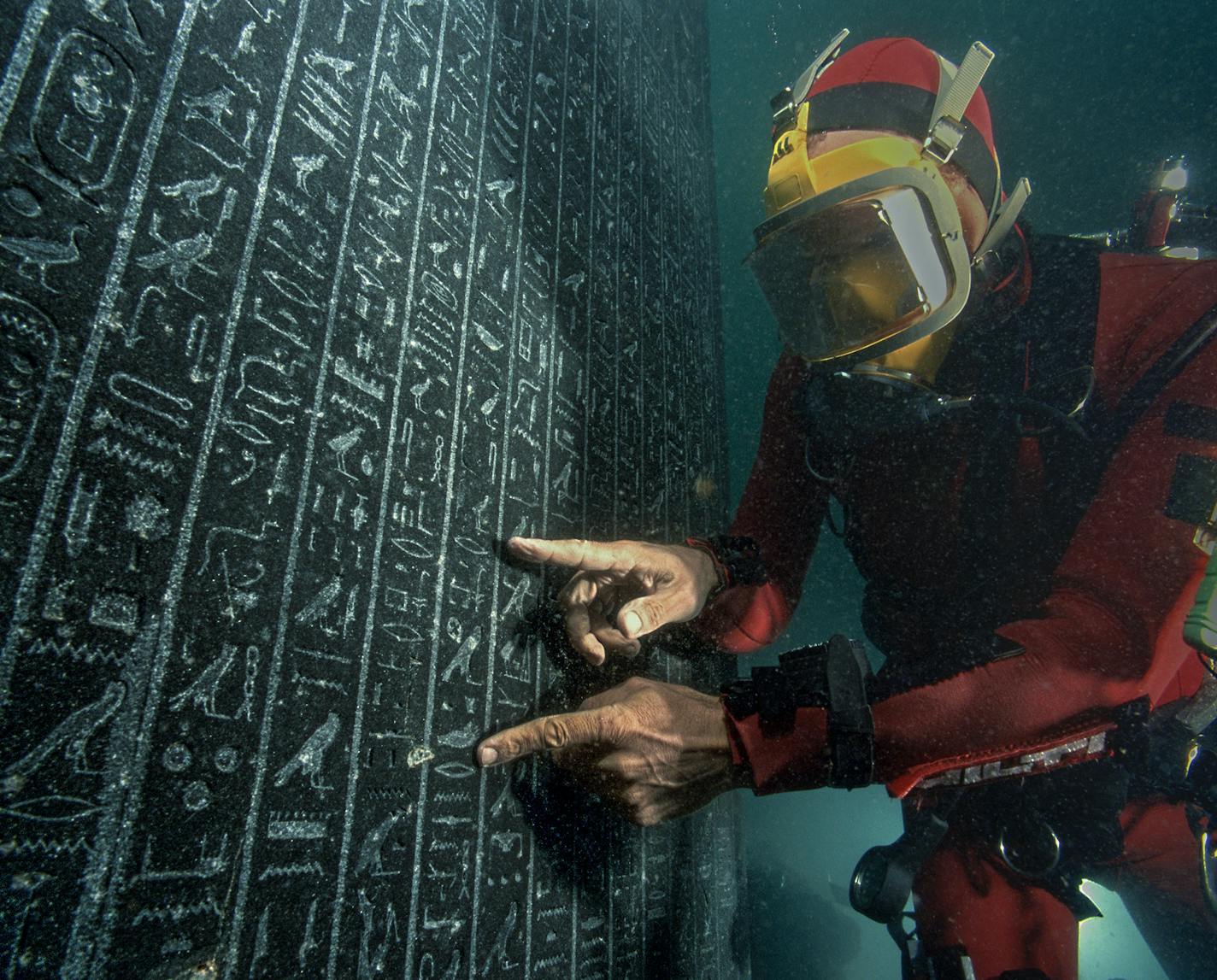 An underwater archaeologist examined a stele, or welcome sign, for Thonis-Heracleion in Aboukir Bay, Egypt.