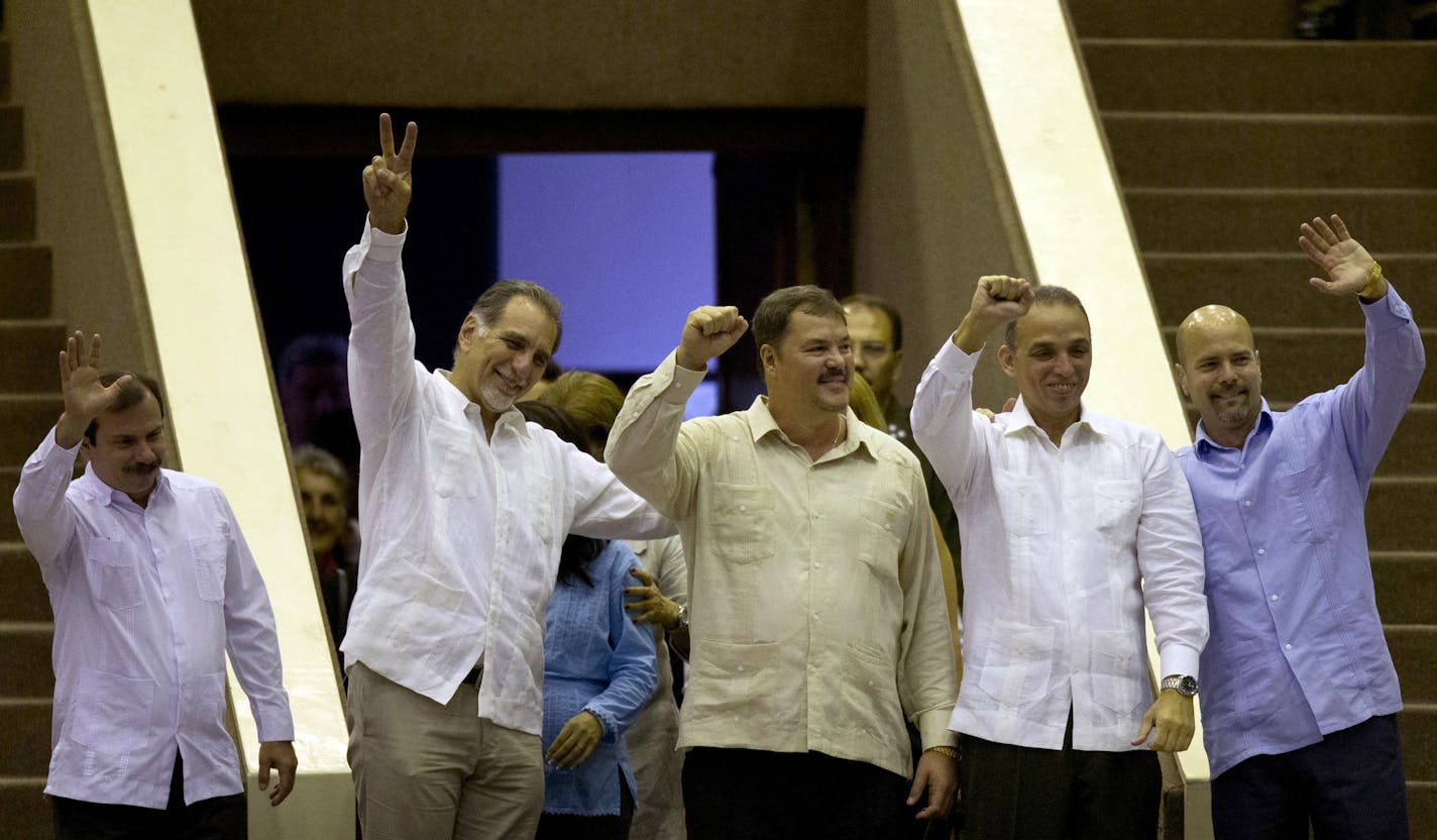 Members of "The Cuban Five," from left, Fernando Gonzalez, Rene Gonzalez, Ramon Labanino, Antonio Guerrero and Gerardo Hernandez wave to members of the National Assembly at the end of the twice-annual legislative session in Havana, Cuba, Saturday, Dec. 20, 2014. Guerrero, Labanino, and Hernandez flew back to their homeland on Wednesday in a quiet exchange of imprisoned spies, part of a historic agreement to restore relations between the two long-hostile countries. Fernando and Rene had been prev