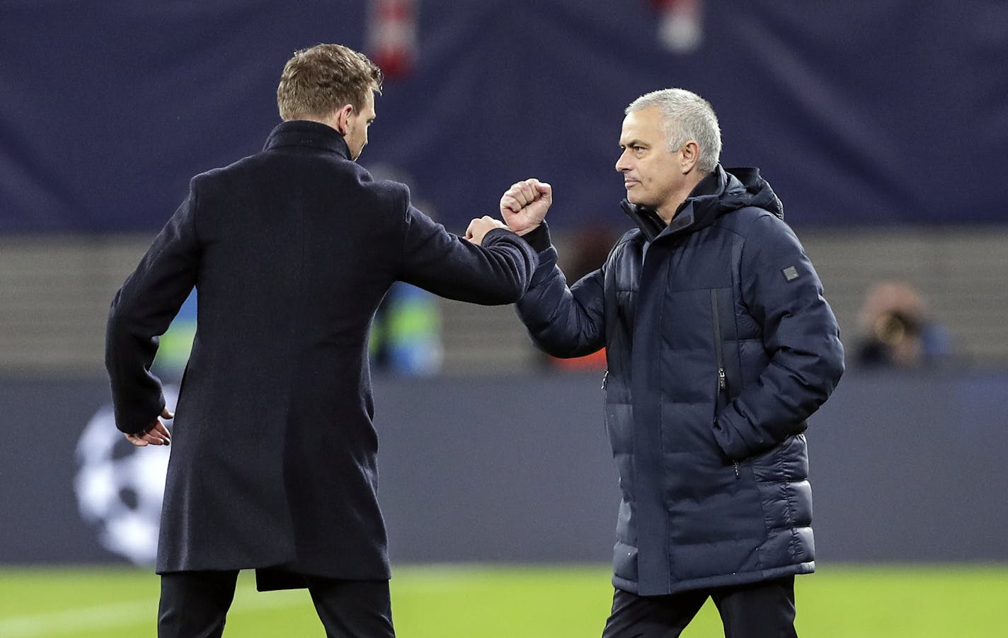 No more handshakes: at a soccer match in Germany earlier this week, Tottenham's manager Jose Mourinho, right, and Leipzig's head coach Julian Nagelsmann touched forearms due to the coronavirus outbreak.