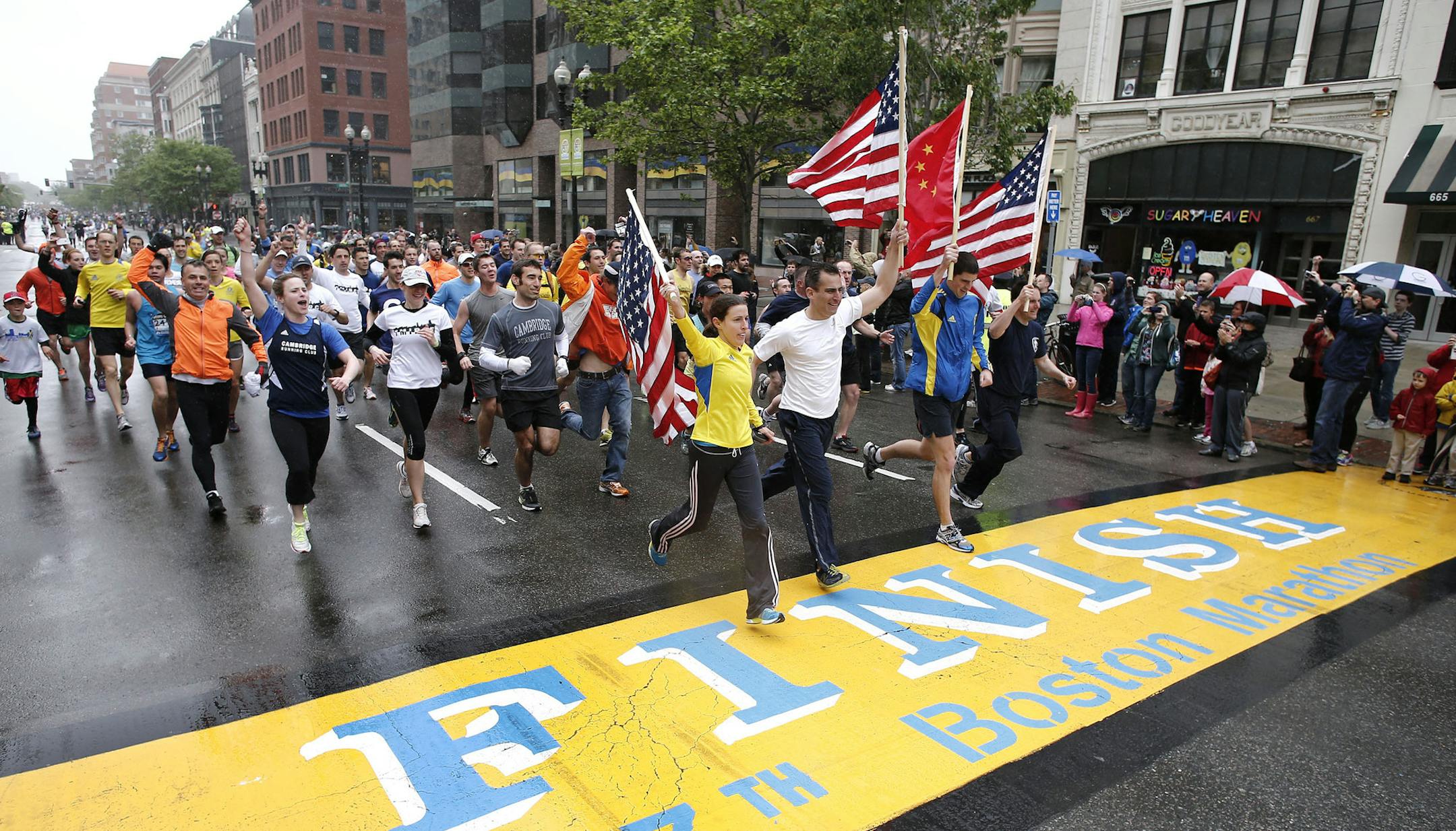 Runners who were unable to finish the Boston Marathon on April 15 because of the bombings cross the finish line on Boylston Street after the city allowed them to finish the last mile of the race in Boston, Saturday, May 25, 2013. (AP Photo/Winslow Townson) ORG XMIT: MIN2013052510421401