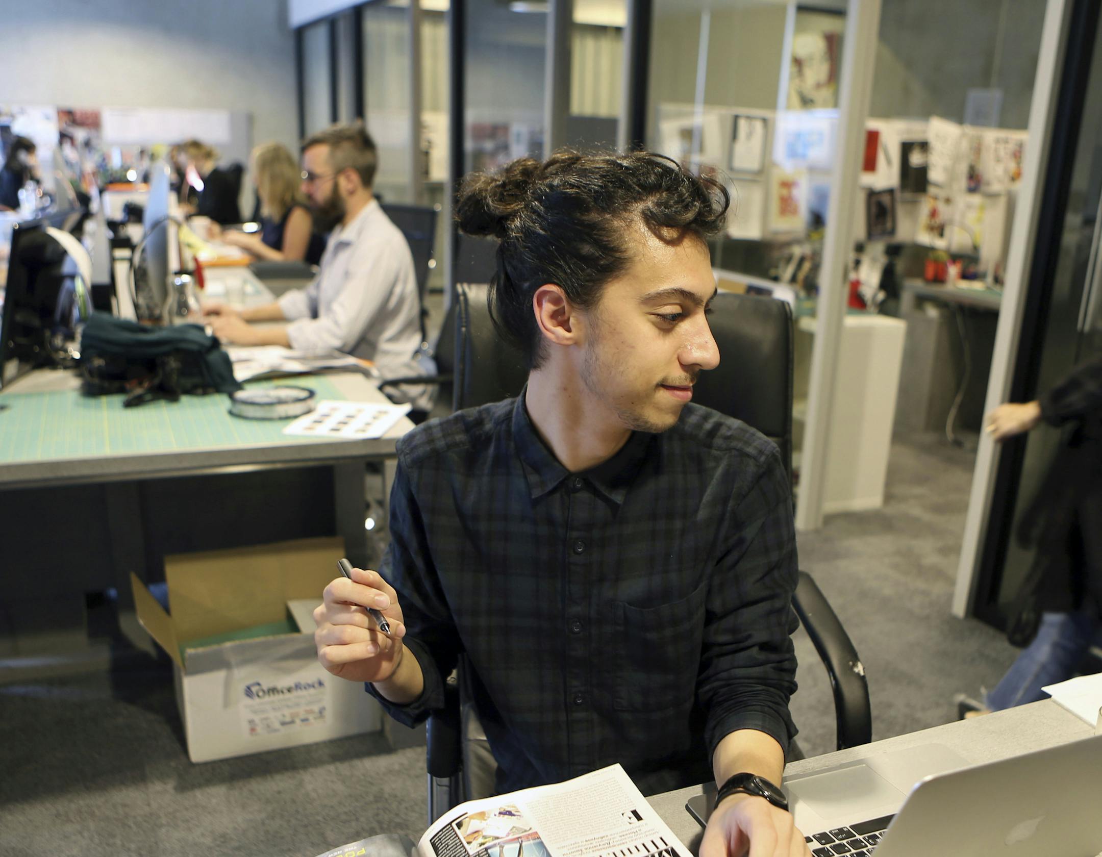 Mohammad Hazem Rezq, one of the Vogue staff works behind his desk at the magazine office at the Dubai Design District in Dubai, United Arab Emirates, Wednesday, March 15, 2017. Vogue launched its 22nd print edition this month in English and Arabic, targeting a niche audience in the Middle East that is fashion conscious, style-driven and wealthy. Vogue Arabia's debut featured on its cover American supermodel Gigi Hadid, whose father is Palestinian, wearing an embellished, mesh veil covering half
