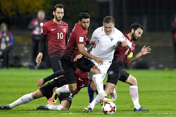 Finland's Robin Lod, second right vies for the ball with Turkey's Hakan Calhanoglu, left, Ismail Koybasi, centre left, Okay Yokuslu, on the ground, an