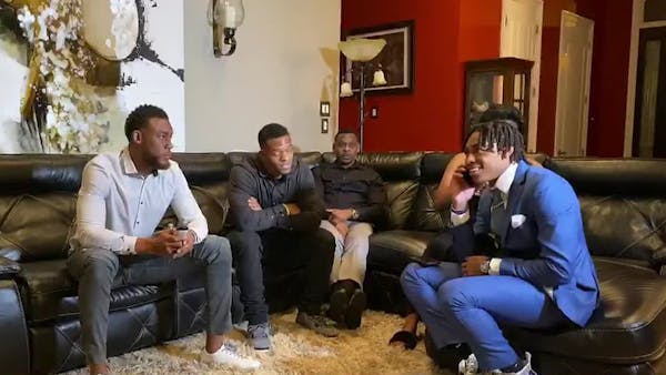 In this still image from video provided by the NFL, Justin Jefferson, right, smiles while watching the draft after being selected by the Vikings.