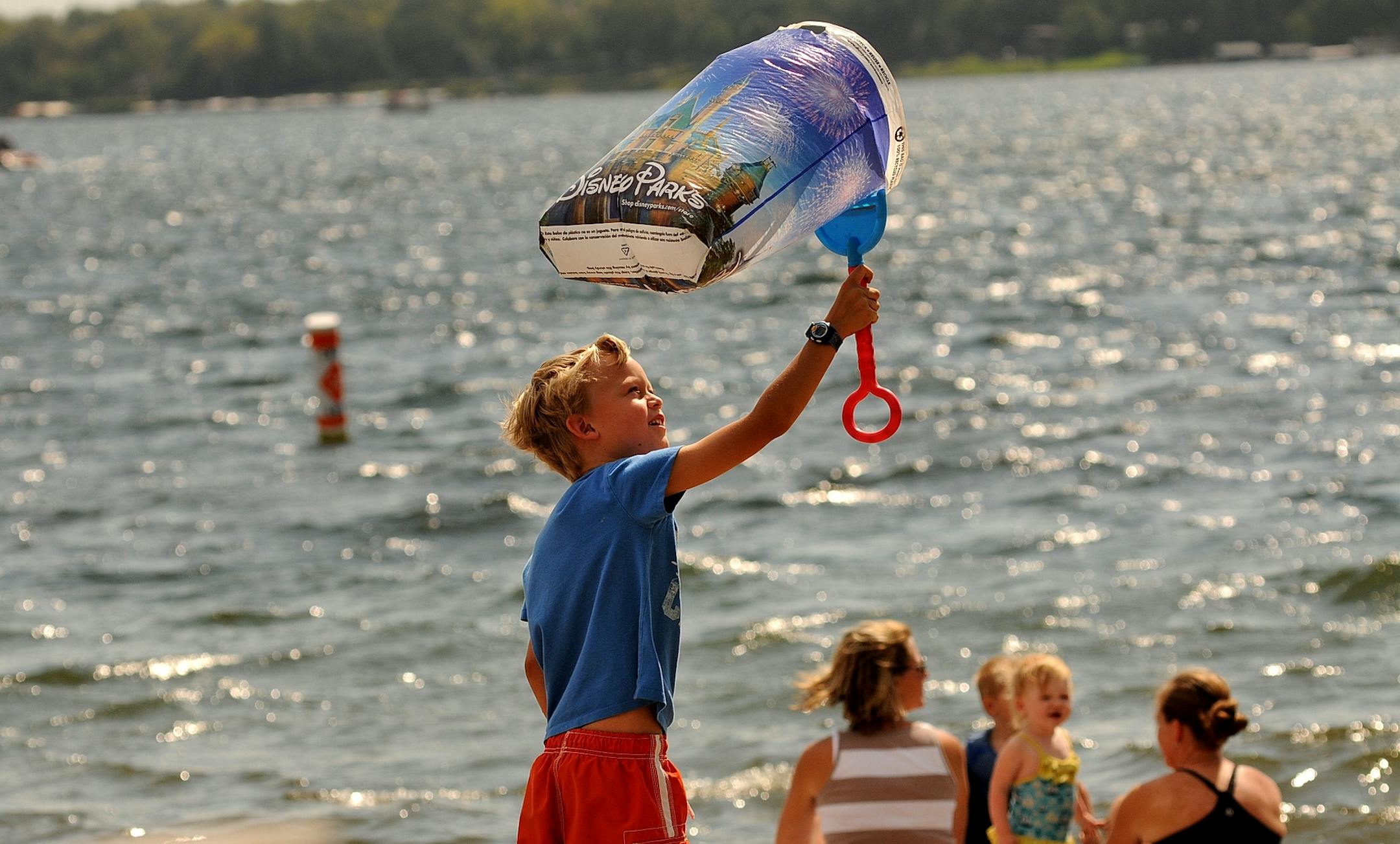 7-year-old Joseph Anderson of Plymouth walked along Lake Minnetonka in Wayzata with a windsock made from a plastic bag and a shovel.