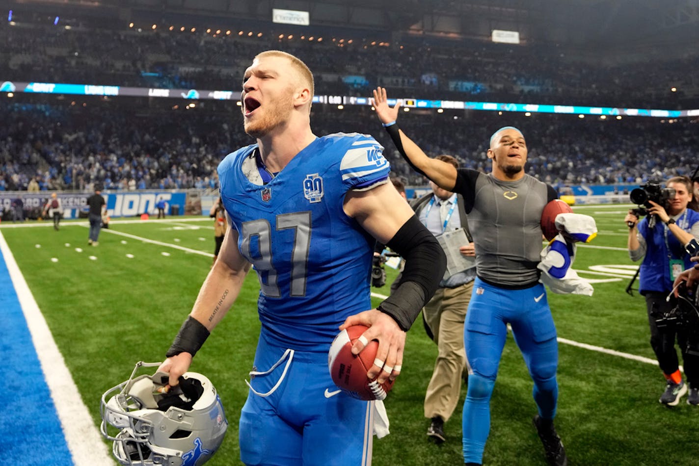 Detroit Lions defensive end Aidan Hutchinson (97) and wide receiver Amon-Ra St. Brown walks off the field after an NFL wild-card playoff football game against the Los Angeles Rams, Sunday, Jan. 14, 2024, in Detroit. (AP Photo/Paul Sancya)