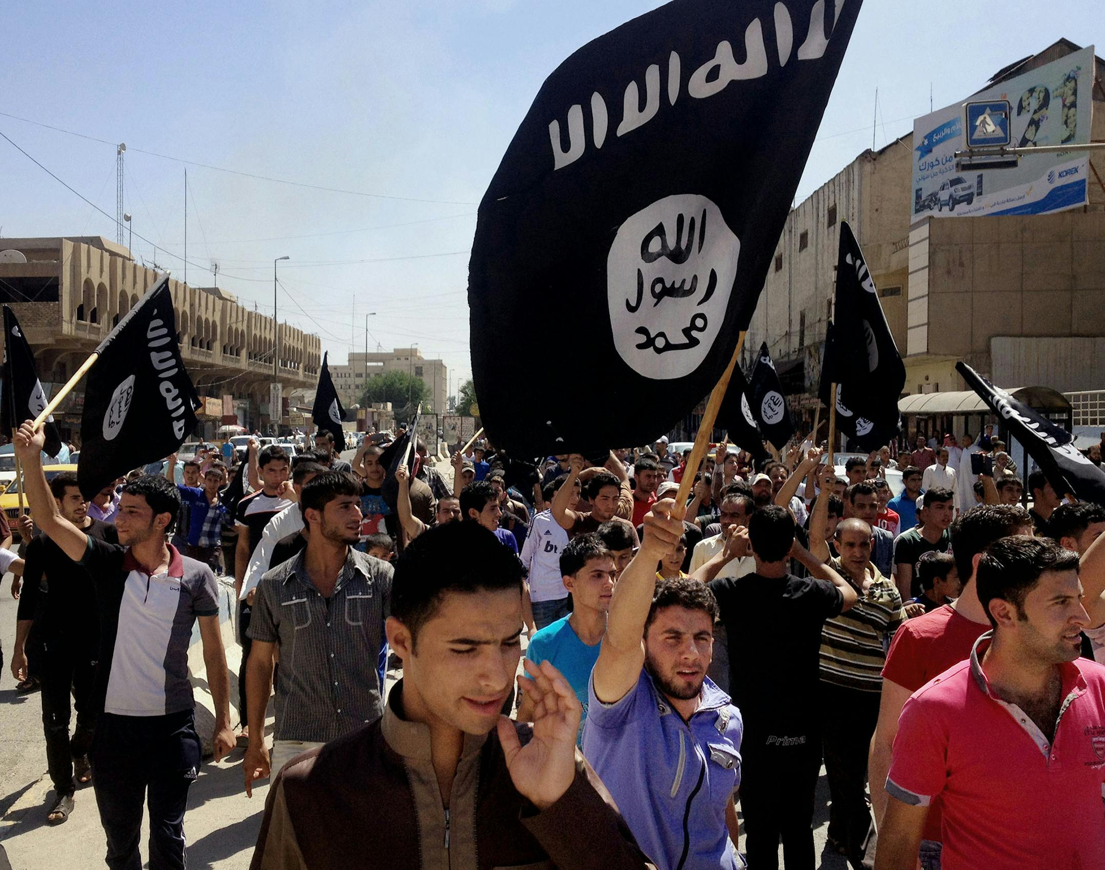 FILE - In this Monday, June 16, 2014 file photo, Demonstrators chant pro-al-Qaida-inspired Islamic State of Iraq and the Levant (ISIL) as they carry al-Qaida flags in front of the provincial government headquarters in Mosul, 225 miles (360 kilometers) northwest of Baghdad, Iraq. In the week since it captured Iraqís second-largest city, Mosul, a Muslim extremist group has tried to win over residents and has stopped short of widely enforcing its strict brand of Islamic law, residents say. Chu