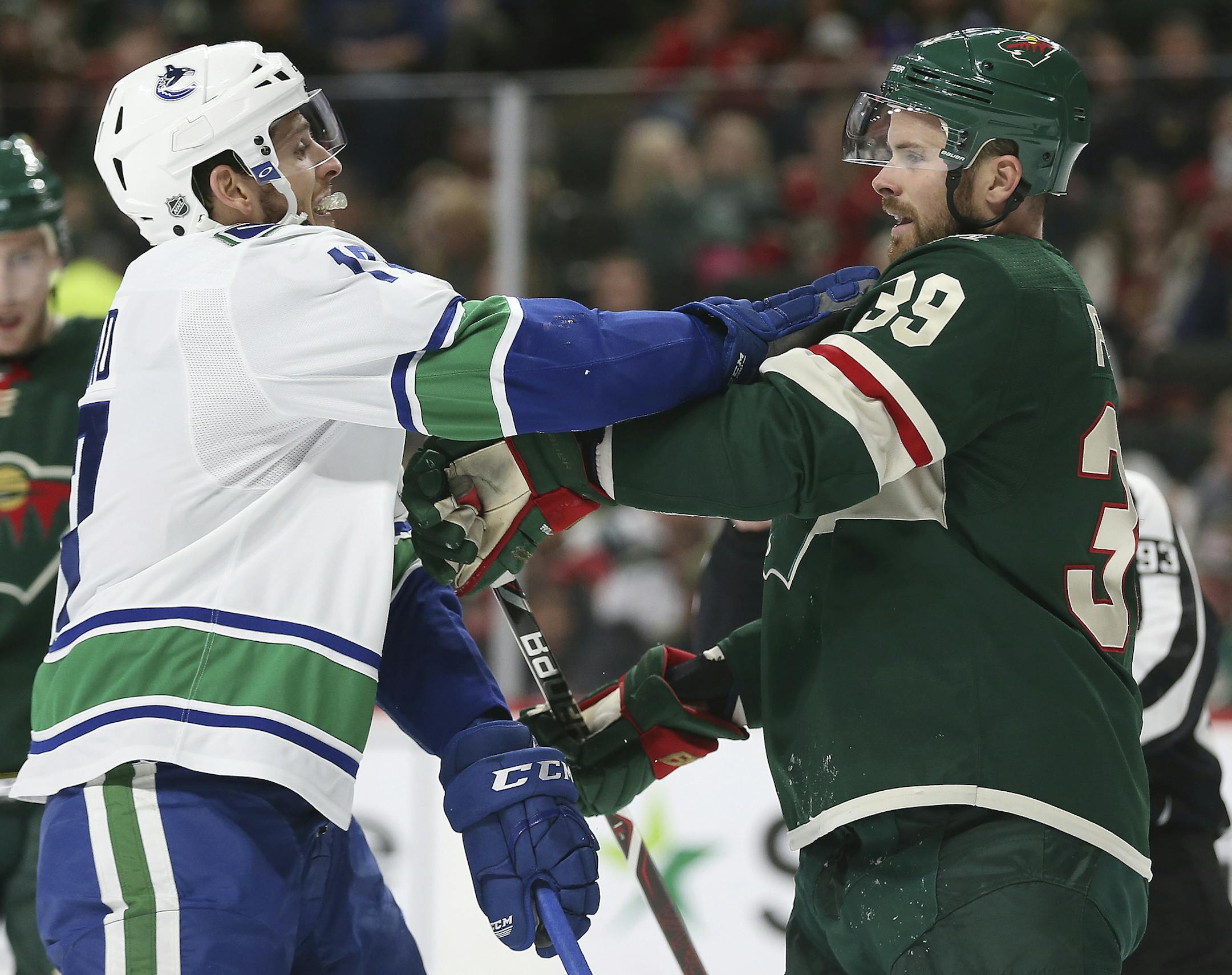 Minnesota Wild's Nate Prosser (39) and Vancouver Canucks Nic Dowd (17) shove each other in the second period of an NHL hockey game Sunday, Jan. 14, 2018, in St. Paul, Minn. (AP Photo/Stacy Bengs)