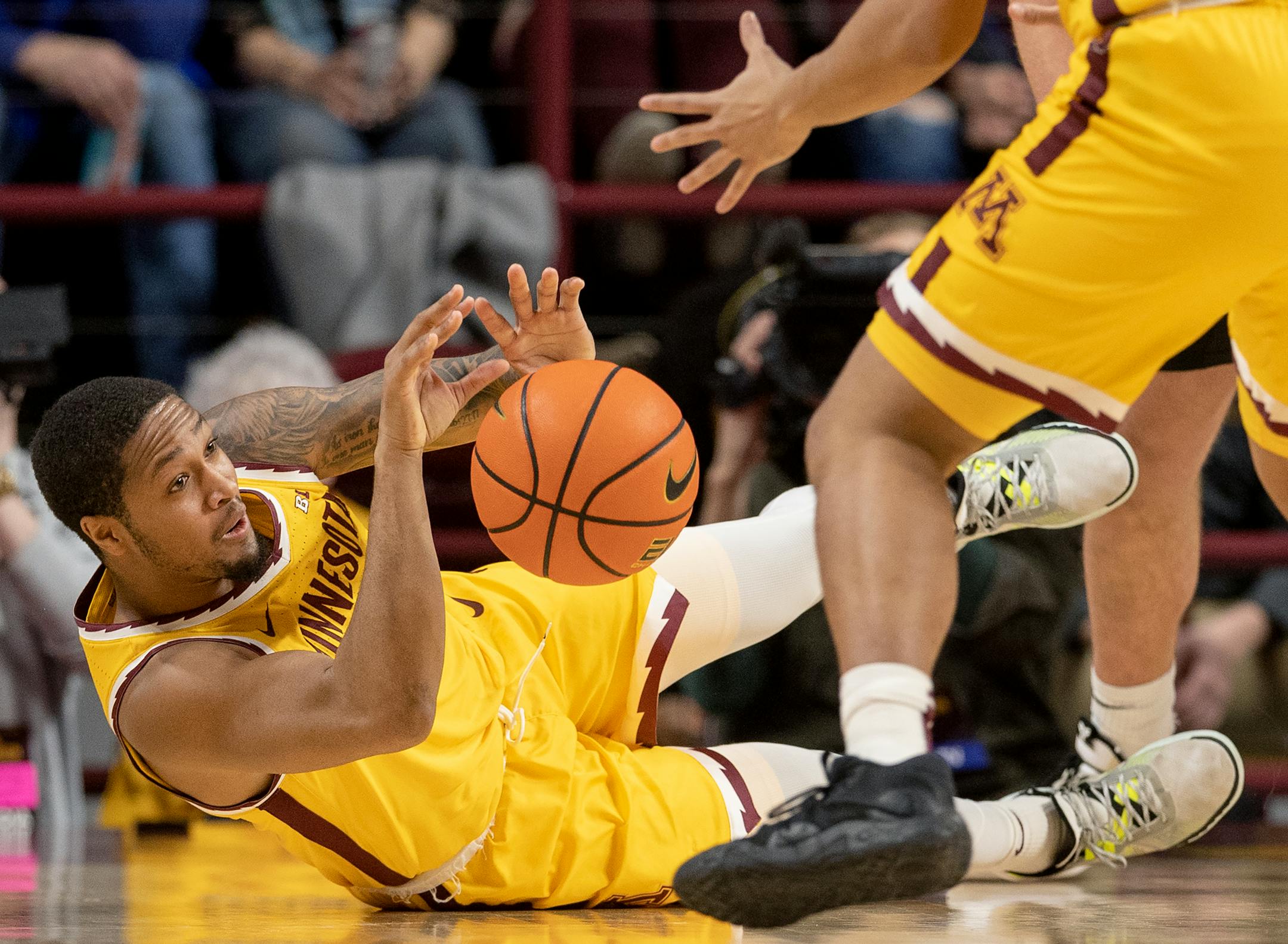 Ta'Lon Cooper (55) of the Minnesota Gophers falls for a loose ball in the first half.