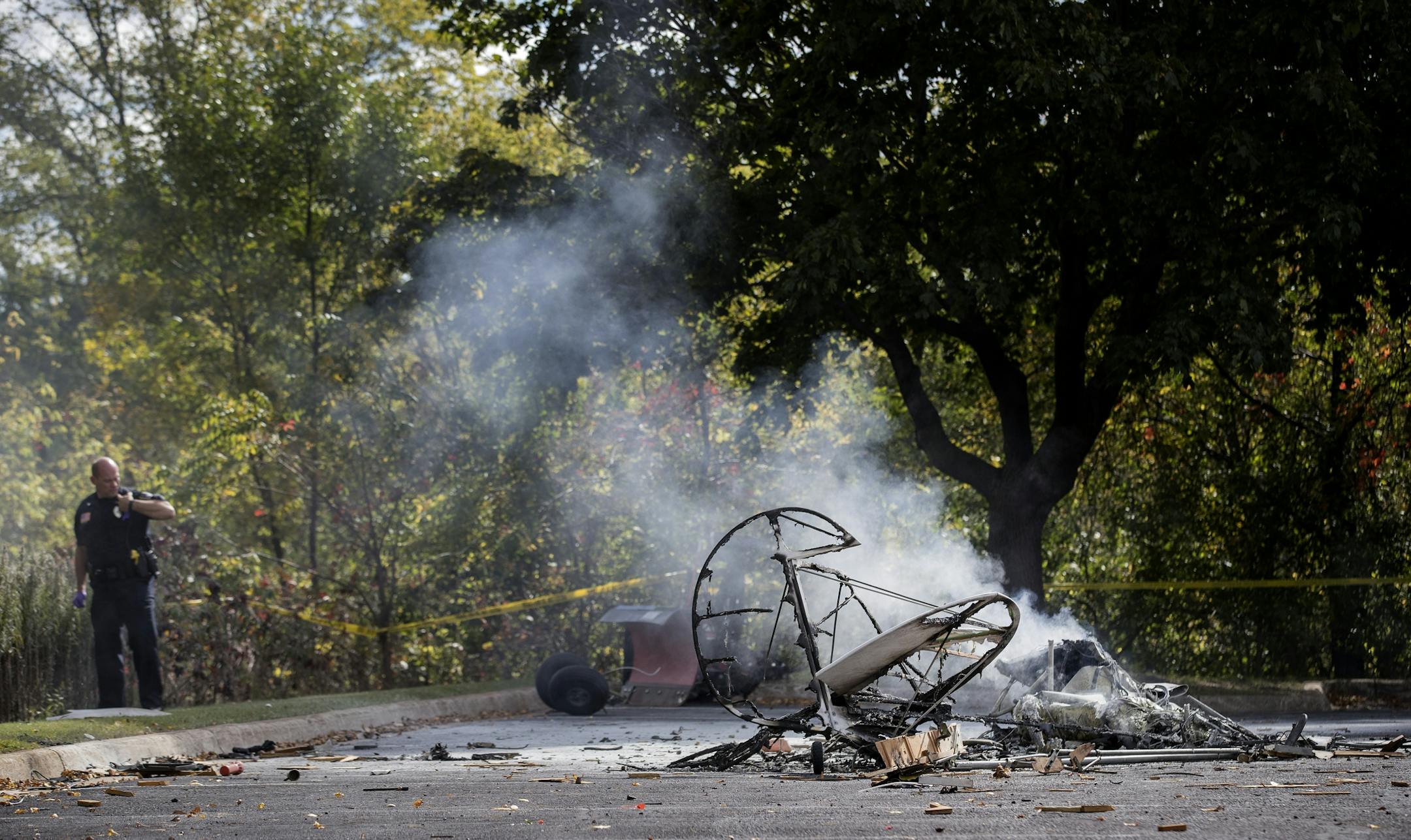A law enforcement officer stood near the wreckage of a small plane that crashed in the parking lot of Resurrection Life Church in Eden Prairie, MN.
