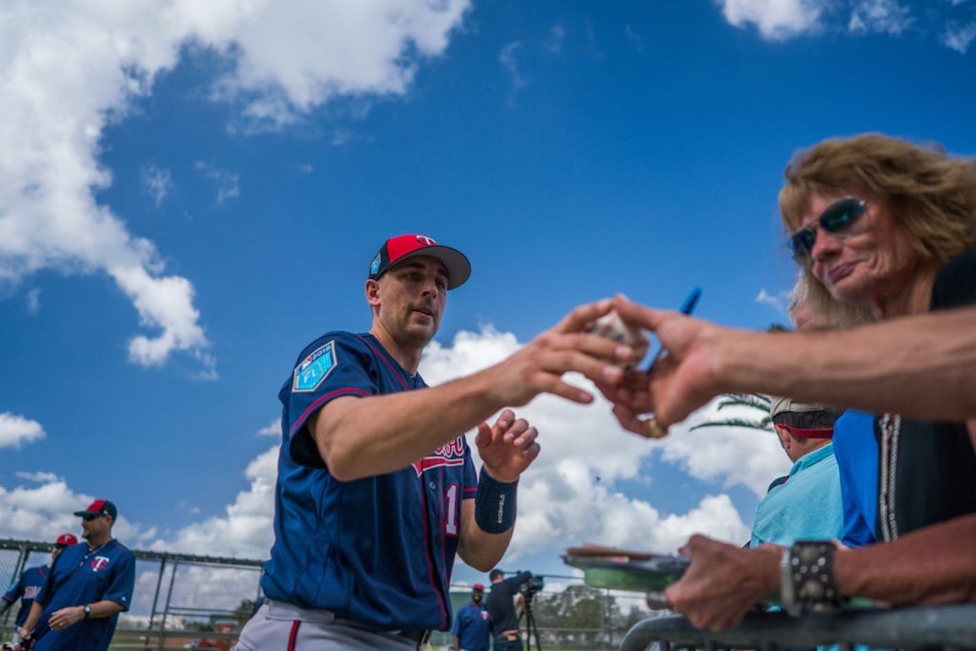 Twins catcher Jason Castro signs a baseball during last year's spring training. Pitchers and catchers reported to camp Wednesday.