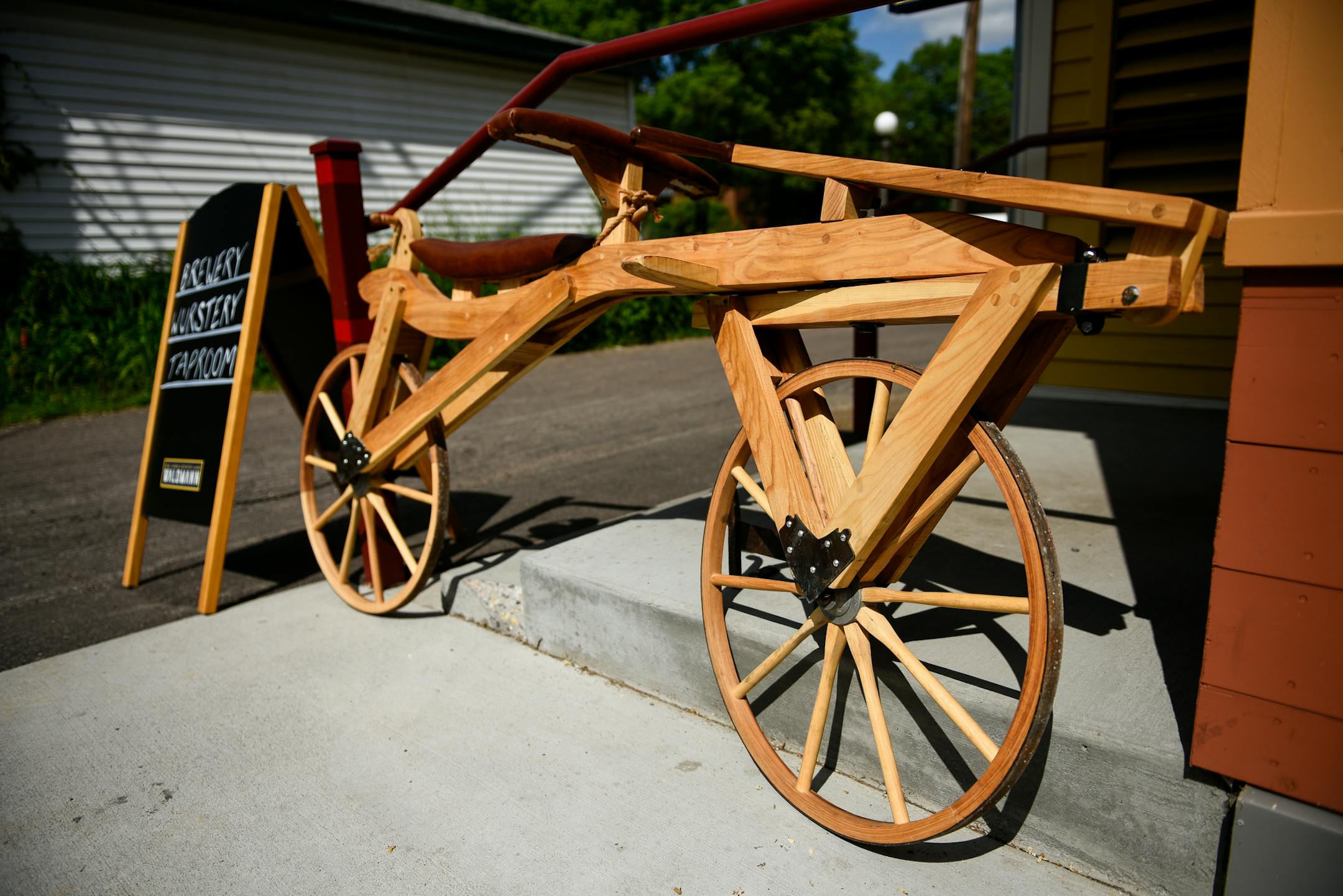 The entrance of Waldmann Brewery and Wurstery Friday afternoon. The management put on display a hand-made wooden replica of an early-1800's German draisine bicycle built by Charles Stephens. ] AARON LAVINSKY ï aaron.lavinsky@startribune.com Cover story on two bike-and-beer routes through Twin Cities taprooms. We photograph Waldmann Brewery and Wurstery on Friday, June 1, 2018 in St. Paul.