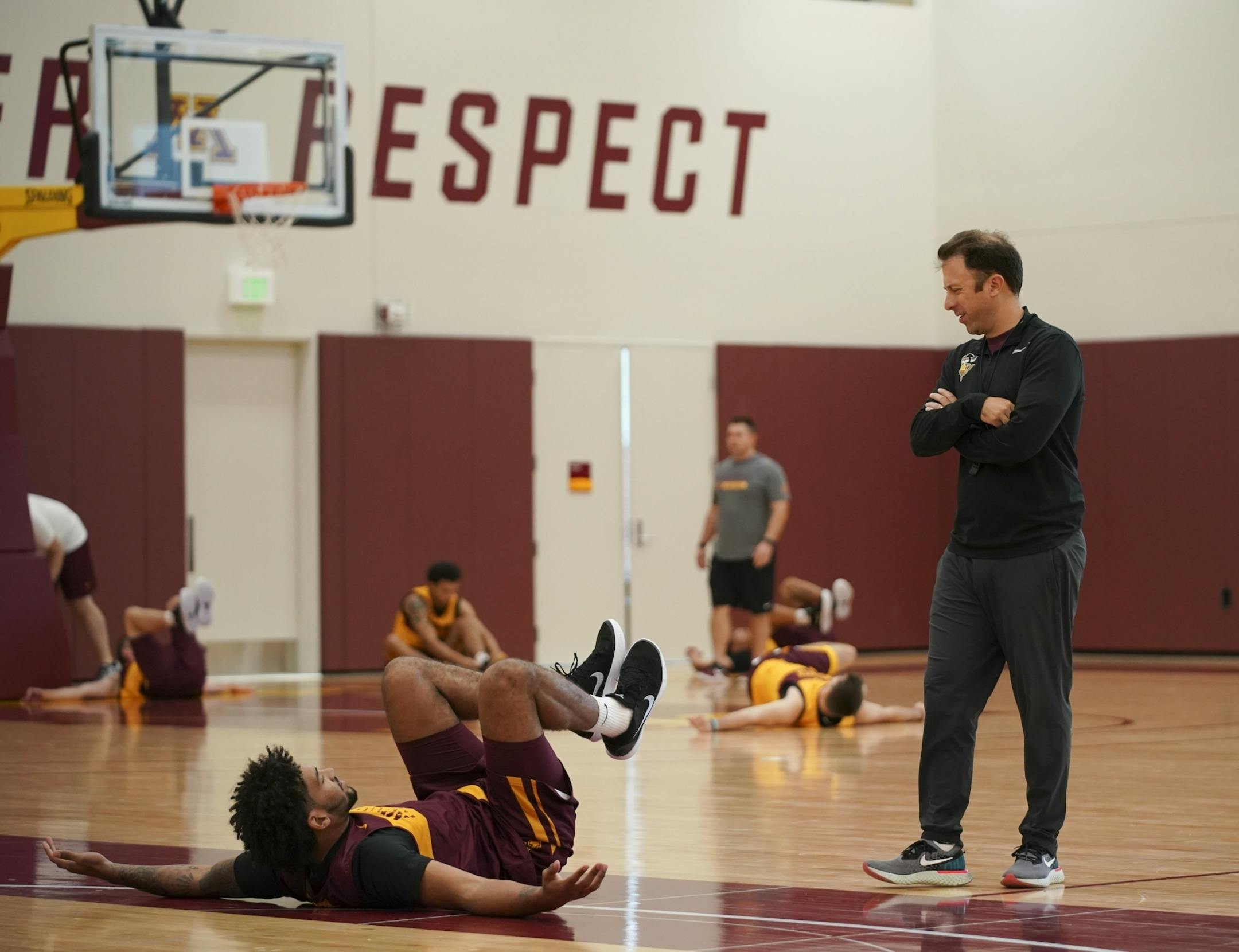 U of M men's head basketball coach Richard Pitino spoke with Jordan Murphy while the team stretched at the start of practice.