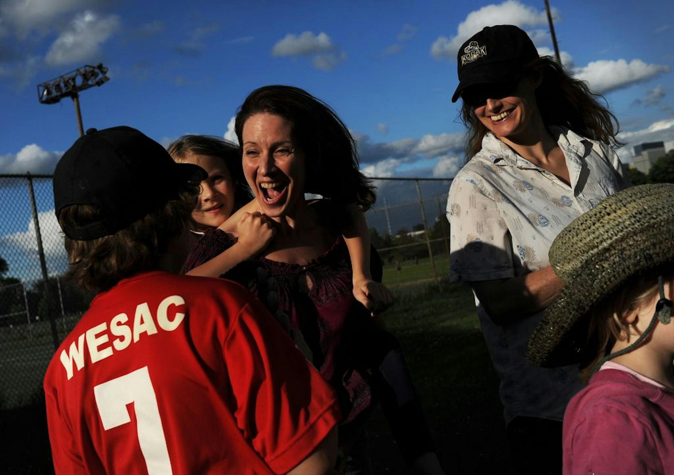 Jennifer Blagen congratulated son Ellery Lawton, 10, left, after a baseball game Monday in Minneapolis. With her were daughters Josie Lawton, 8, getting a ride on mom's back, and Mathilda Lawton, 4, far right. Tammara Melloy, top right, rounded out the cheering section.
