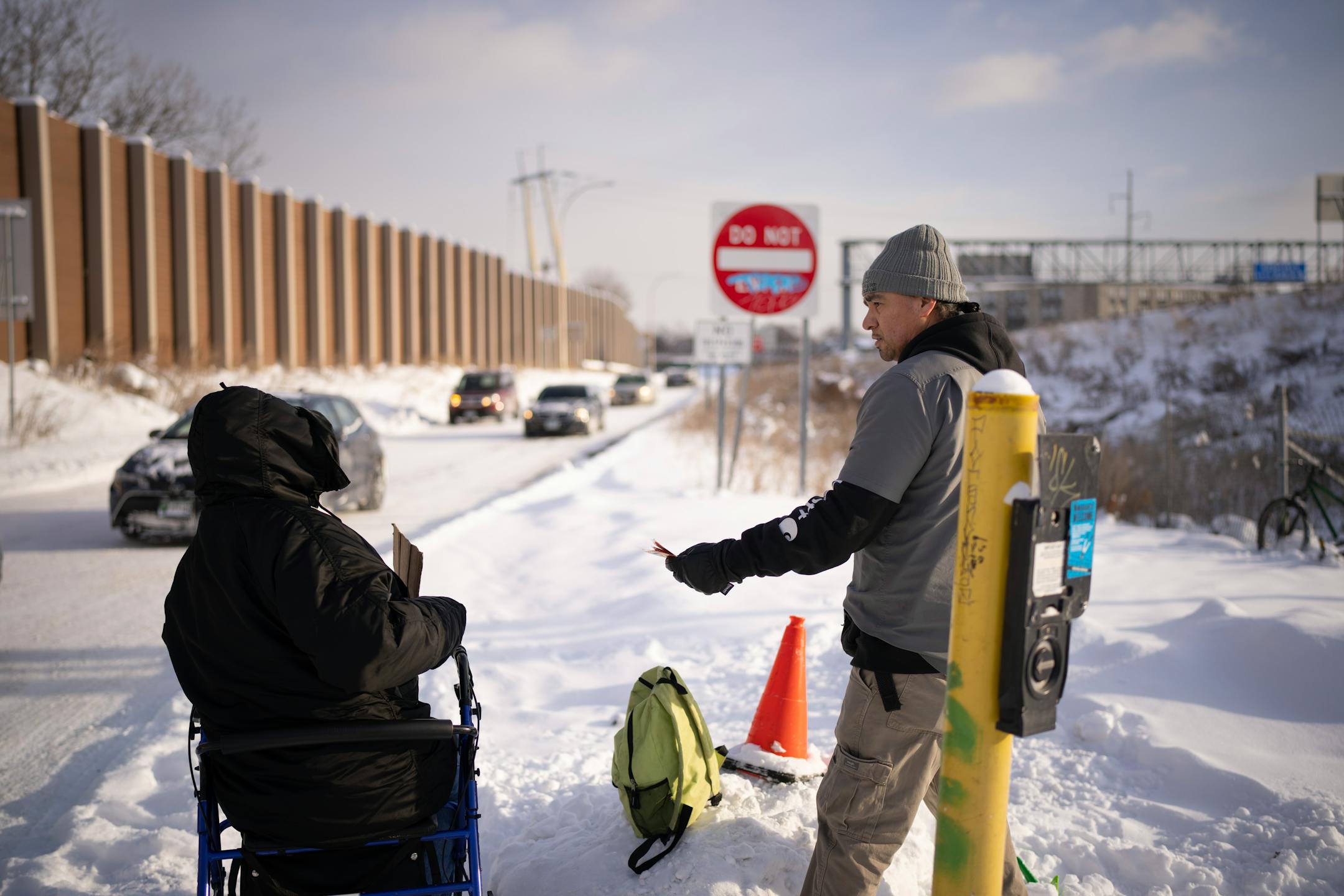 Vinny Dionne offered a homeless man hand warmers and a bottle of water while he sought donations from drivers exiting I-94 onto Cedar Ave. Thursday afternoon. Homeless outreach workers from the American Indian Community Development Corp. (AICDC), checked several homeless encampments to offer hand warmers and snacks or a ride to a shelter on a dangerously cold afternoon in Minneapolis Thursday, December 22, 2022.