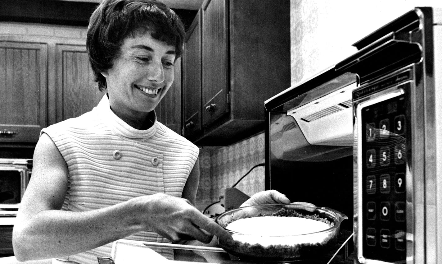 July 8, 1975 Janet Sadlack with cheese cake baked in microwave in 5 minutes - Microwave oven owners enjoy what the rest of us envy --- a cool kitchen in hot summer months. Because microwaves cook food from the inside, the oven doesn't heat the kitchen or the cook. "In Winter you might not prepare a particular dish in the microwave, but in summer you're certain to switch," says Janet Sadlack, author of "Enjoying Microwave Cooking, Discovering Delicious Recipes," published by Recipes Unlimited, 96