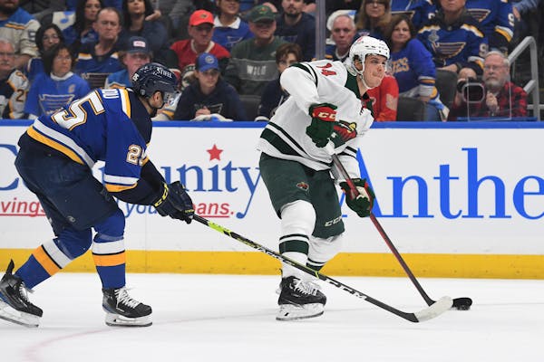 The Wild's Joel Eriksson Ek works the puck against the Blues' Jordan Kyrou during the first period in Game 3