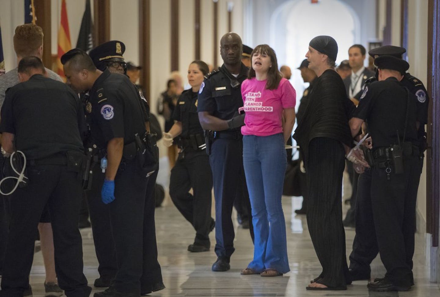 Activists protesting against the Republican health care bill outside Senate offices are taking into custody by U.S. Capitol Police, Monday, July 10, 2017, on Capitol Hill in Washington.