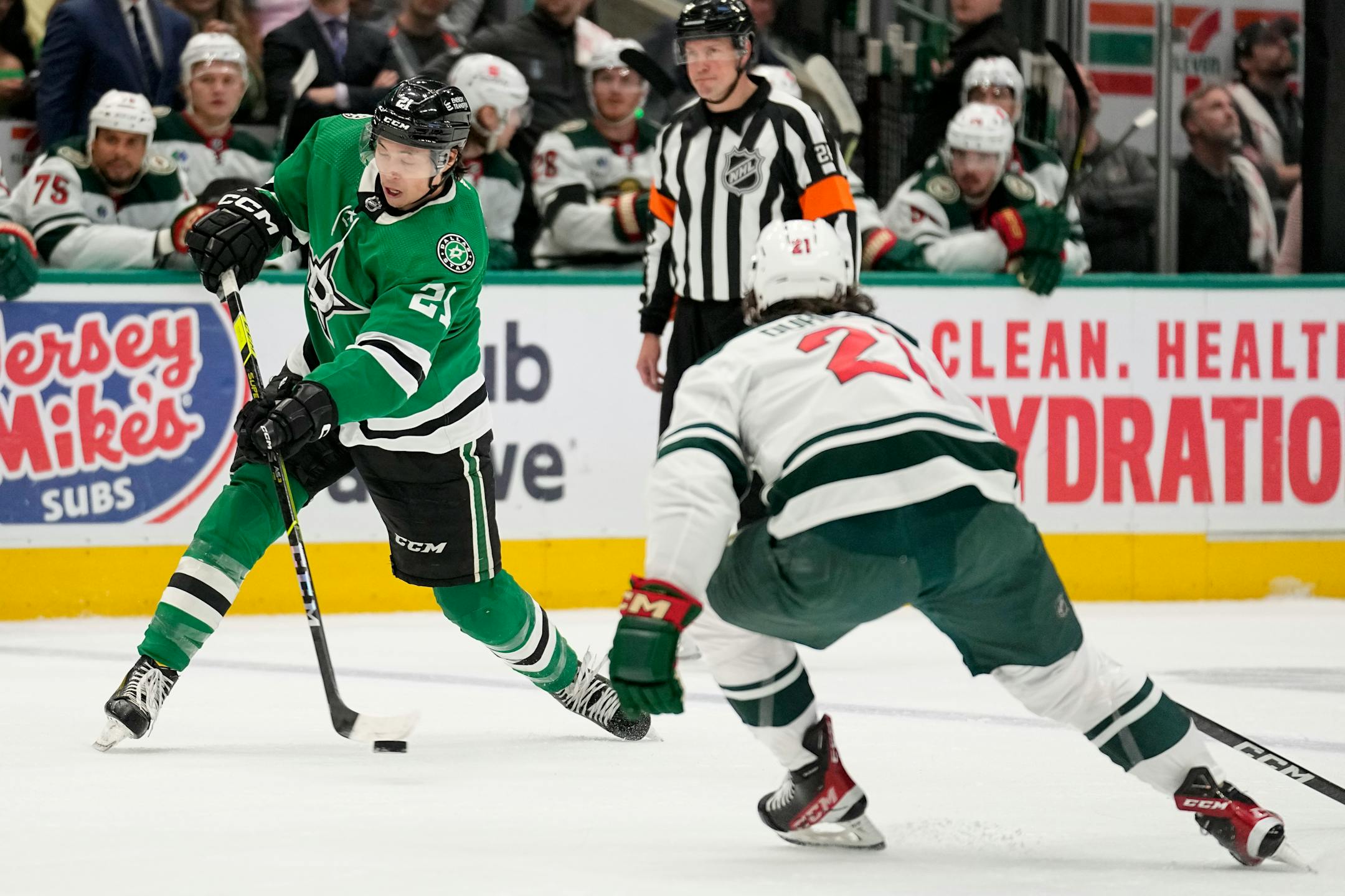 Dallas Stars left wing Jason Robertson, left, takes a shot as Minnesota Wild right wing Brandon Duhaime, right, defends in the first period of Game 2.